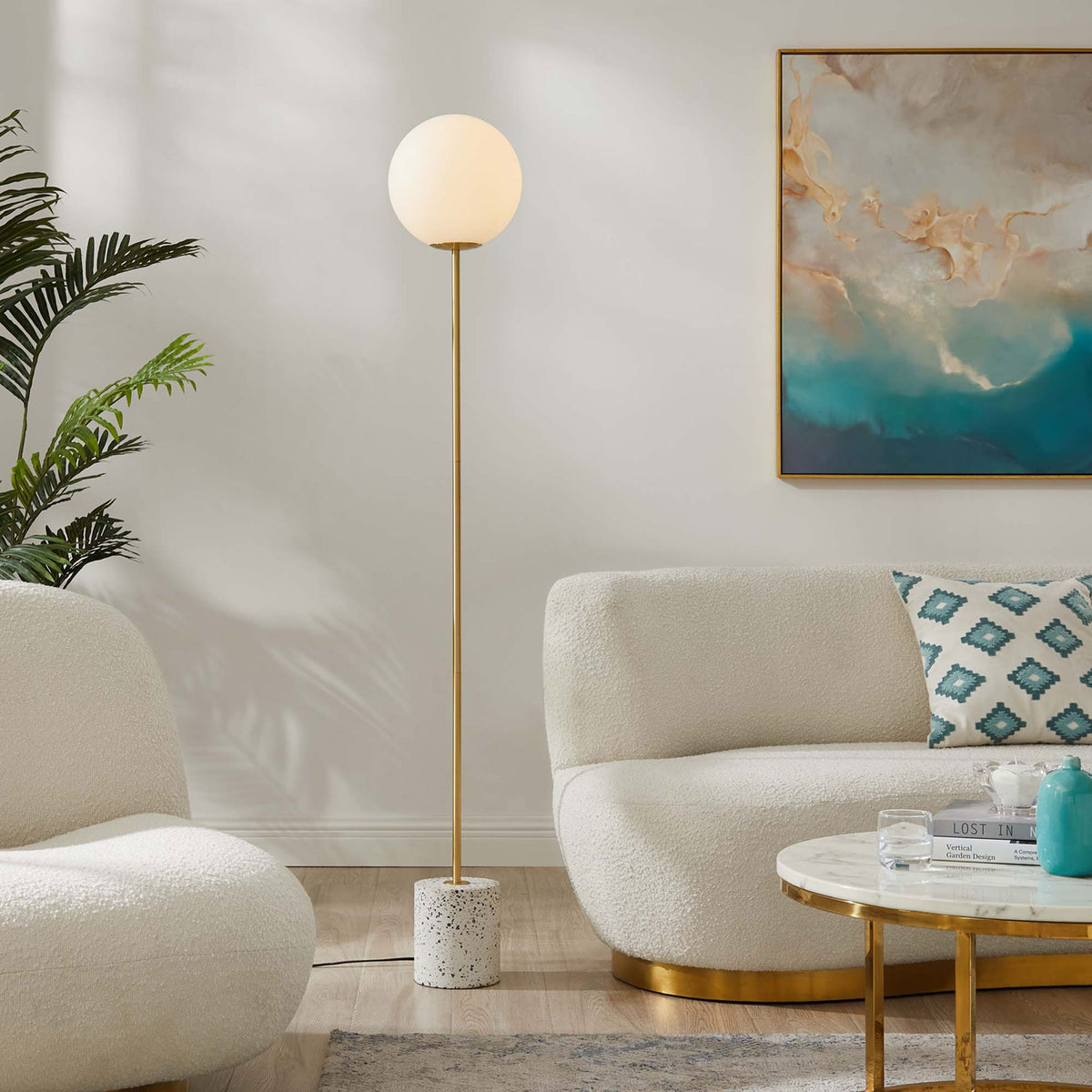 Logic floor lamp glowing warmly in a contemporary living room with plush white seating and art || EEI-5626-WHI || front_on_room