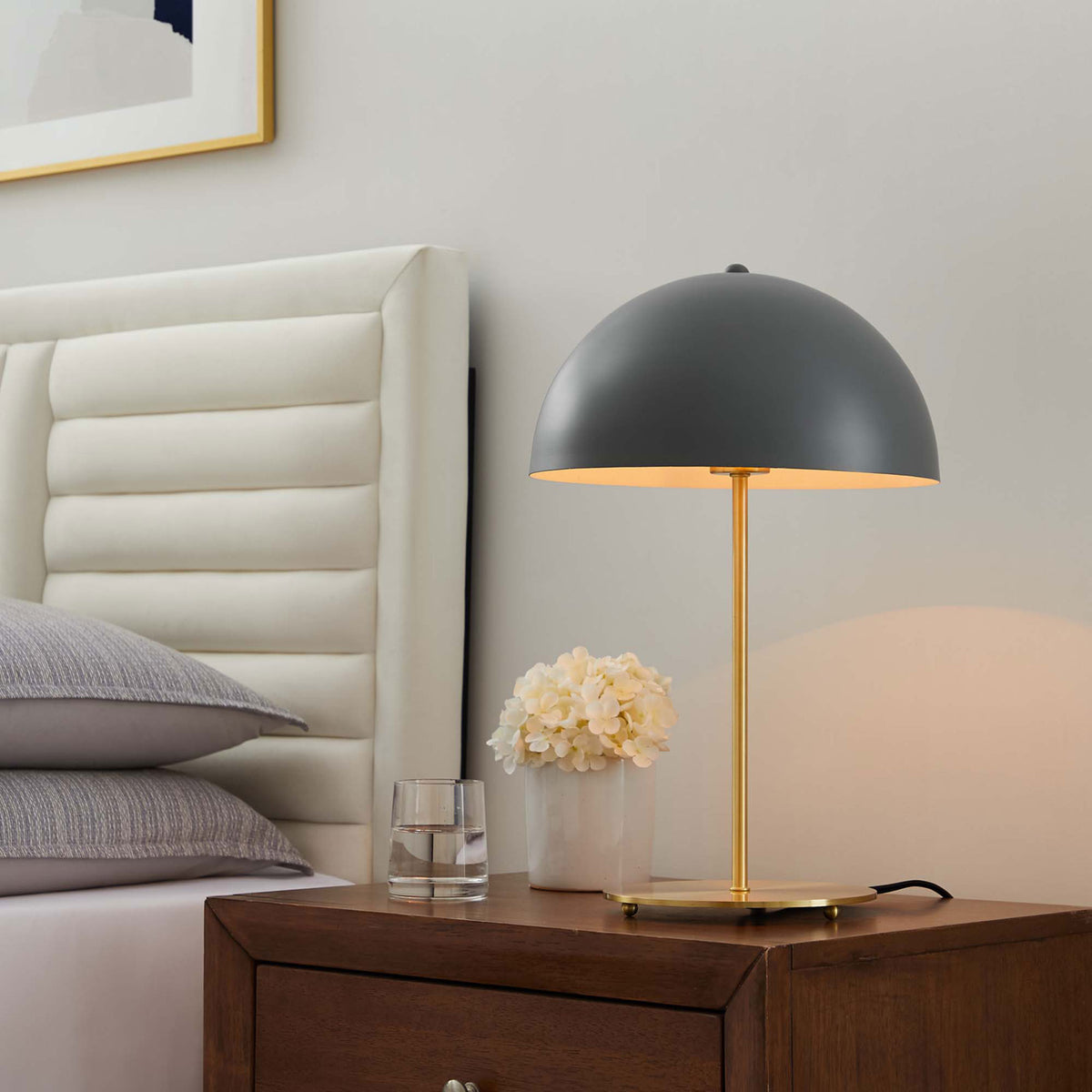 Gray dome lamp casting a warm bedside glow against the wall and headboard in a cozy bedroom || EEI-5629-GRY-SBR || front_angle_on_room