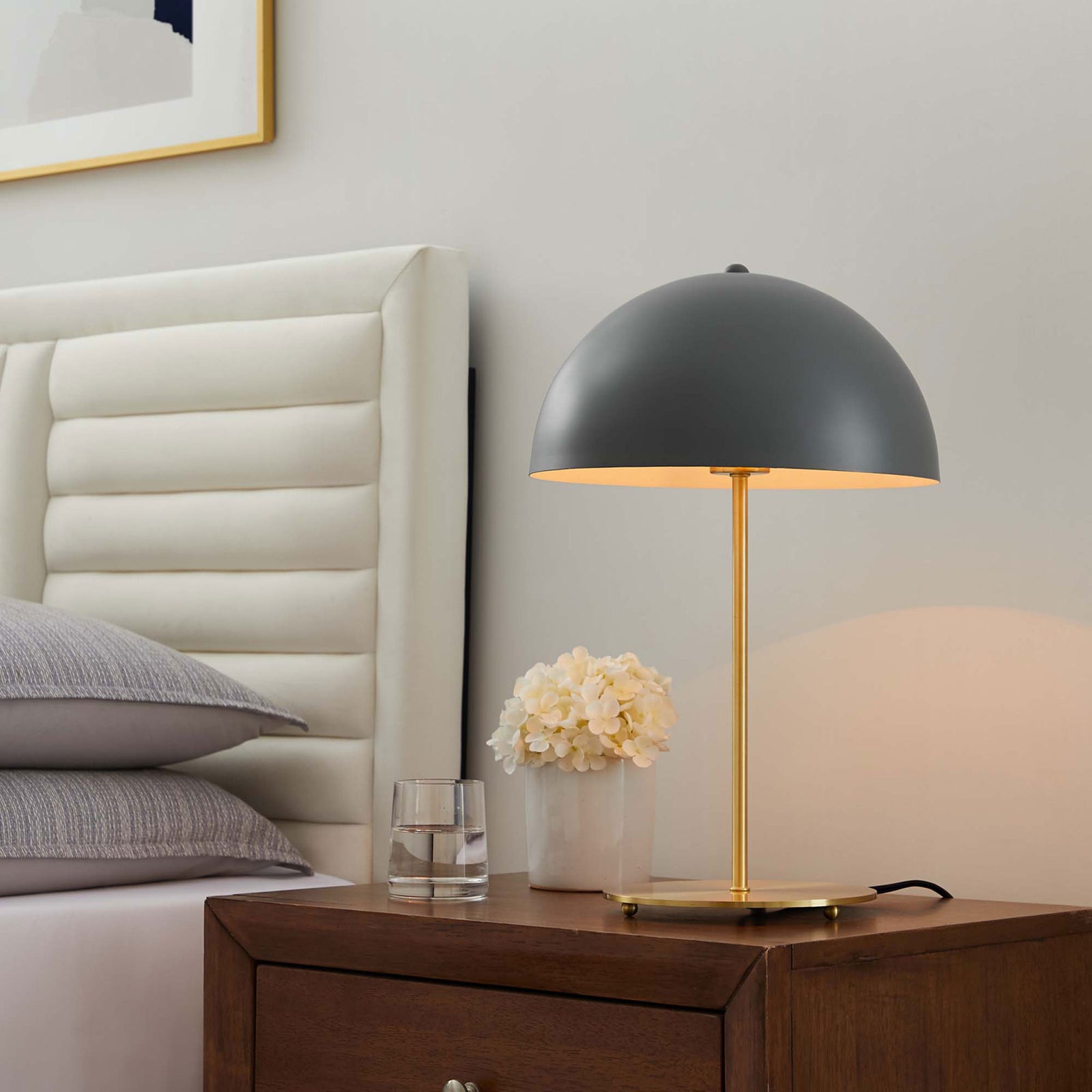 Gray dome lamp casting a warm bedside glow against the wall and headboard in a cozy bedroom || EEI-5629-GRY-SBR || front_angle_on_room
