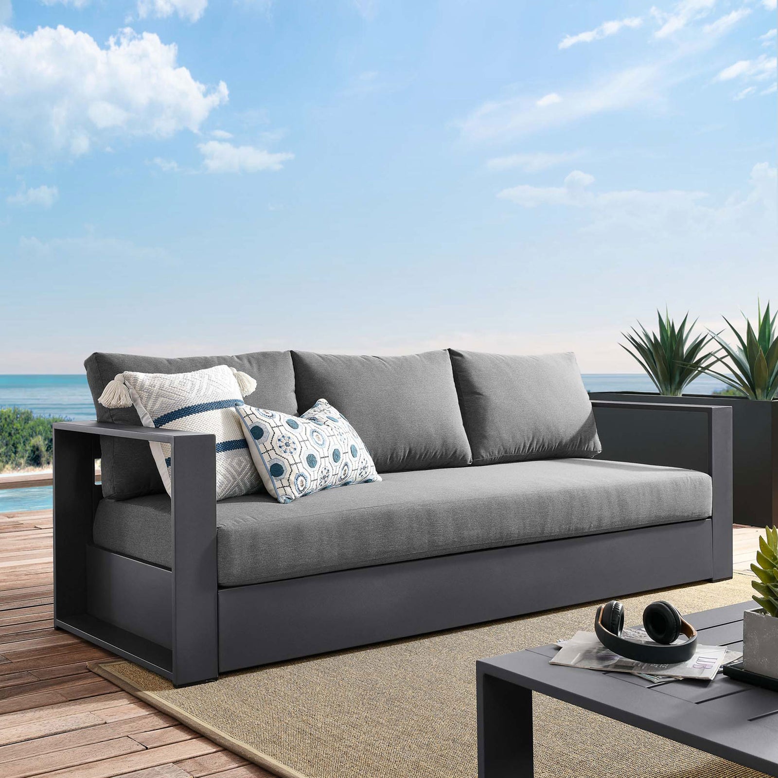 Tahoe outdoor sofa in charcoal and gray styled on a coastal deck with accent pillows. || EEI-5676-GRY-CHA || front_angle_room