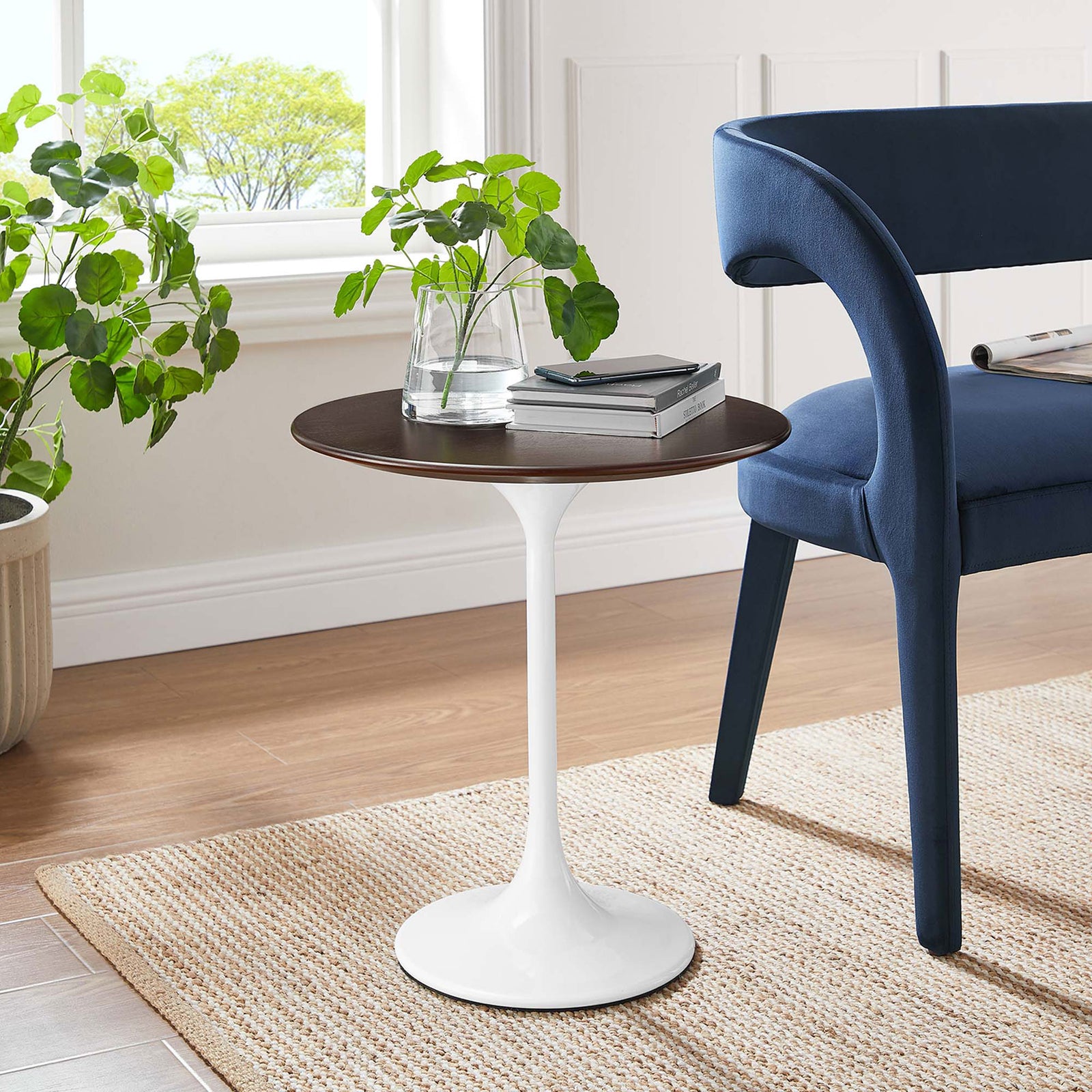 Round side table with dark wood top and white pedestal base beside a modern blue accent chair || EEI-5679-WHI-CHE || front_angle_room