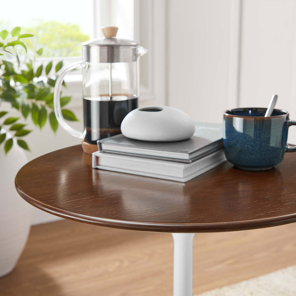 Warm walnut tabletop styled with coffee press, books, and decor in a bright living room || EEI-5679-WHI-WAL || detail_room