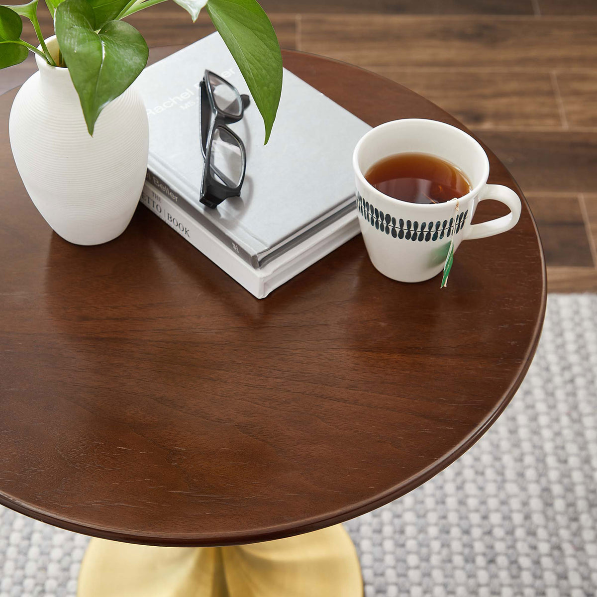 Styled walnut side table top with book, plant, glasses, and tea cup in a cozy room || EEI-5684-GLD-WAL || detail_room