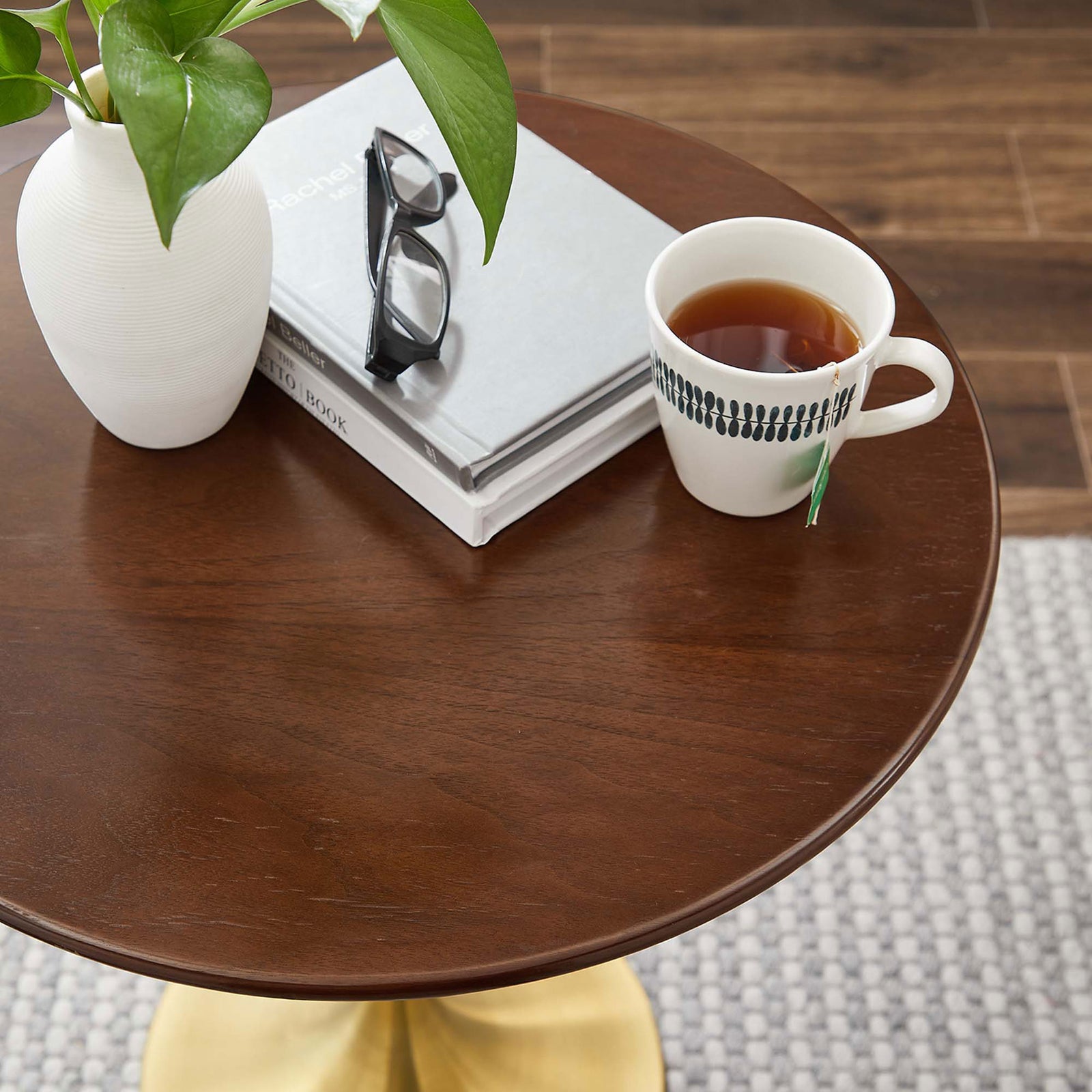 Styled walnut side table top with book, plant, glasses, and tea cup in a cozy room || EEI-5684-GLD-WAL || detail_room