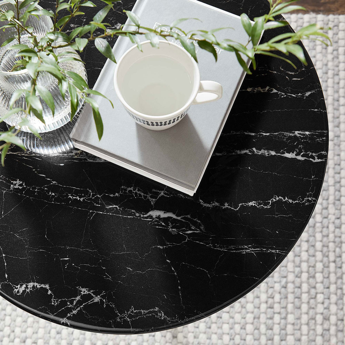Styled black faux marble side table top with greenery, mug, and books in a cozy room setting || EEI-5685-GLD-BLK || detail_room