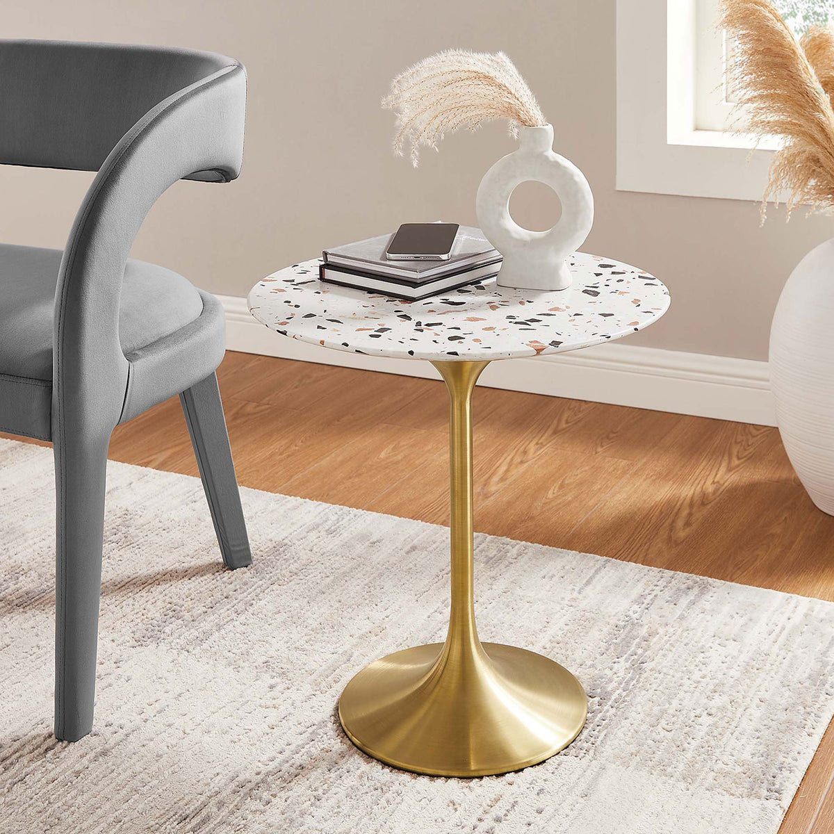 Lippa gold terrazzo side table adding mid century charm beside a modern accent chair || EEI-5687-GLD-TER || front_angle_room