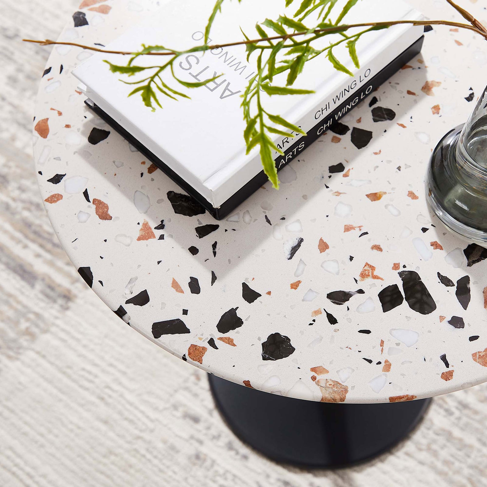 Terrazzo side table styled with books and a vase, highlighting multicolor chips and smooth surface || EEI-5692-BLK-TER || detail_room