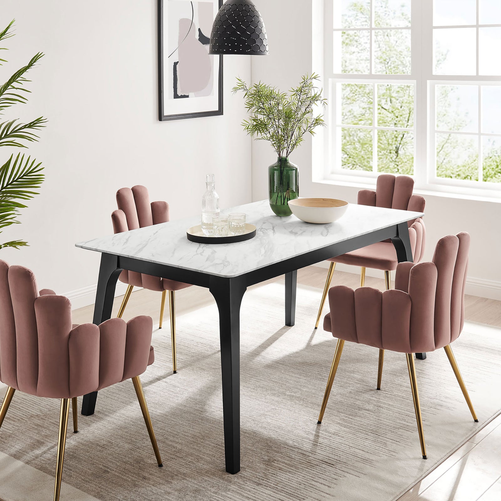 Marble dining table anchoring a light-filled dining room styled with greenery and blush accent chairs || EEI-5693-BLK-WHI || front_angle_room
