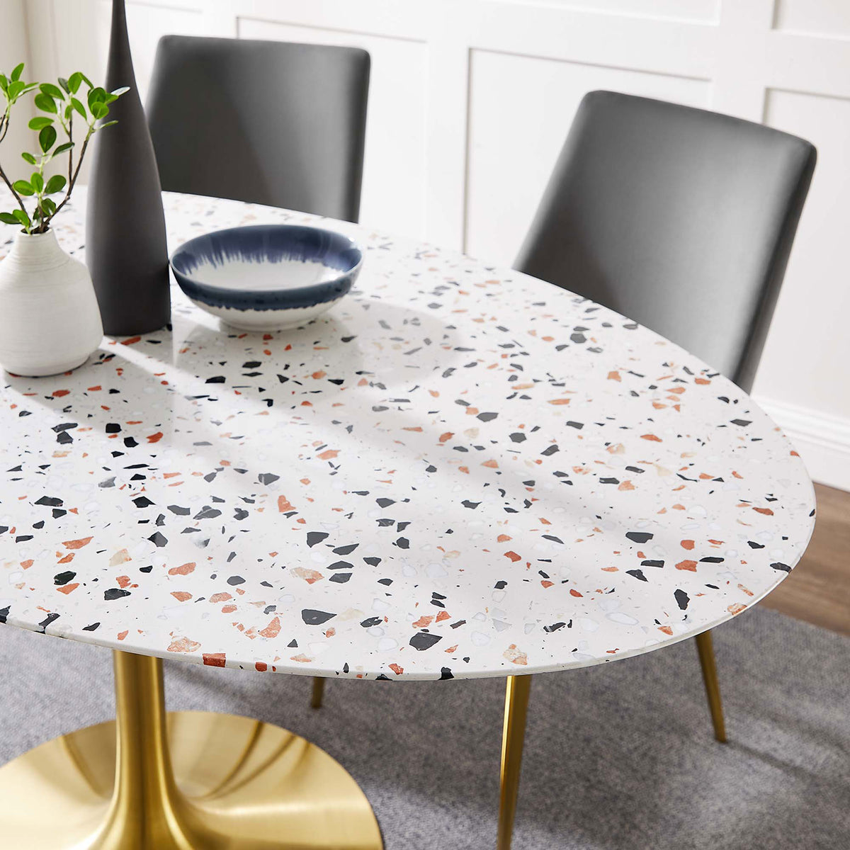 The terrazzo tabletop styled with decor shows its smooth surface and colorful stone chips || EEI-5736-GLD-WHI || detail_room