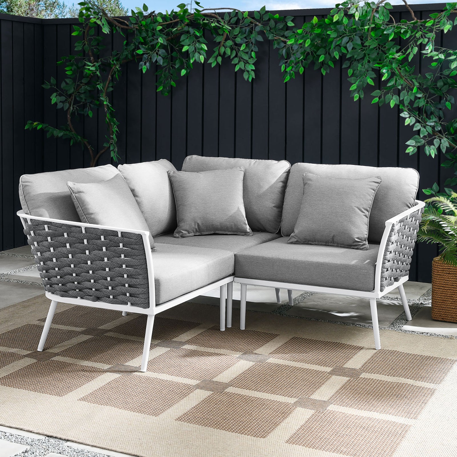 Gray rope sectional anchors a modern patio with white frame, taupe outdoor rug, and lush greenery || EEI-5752-WHI-GRY || front_angle_room