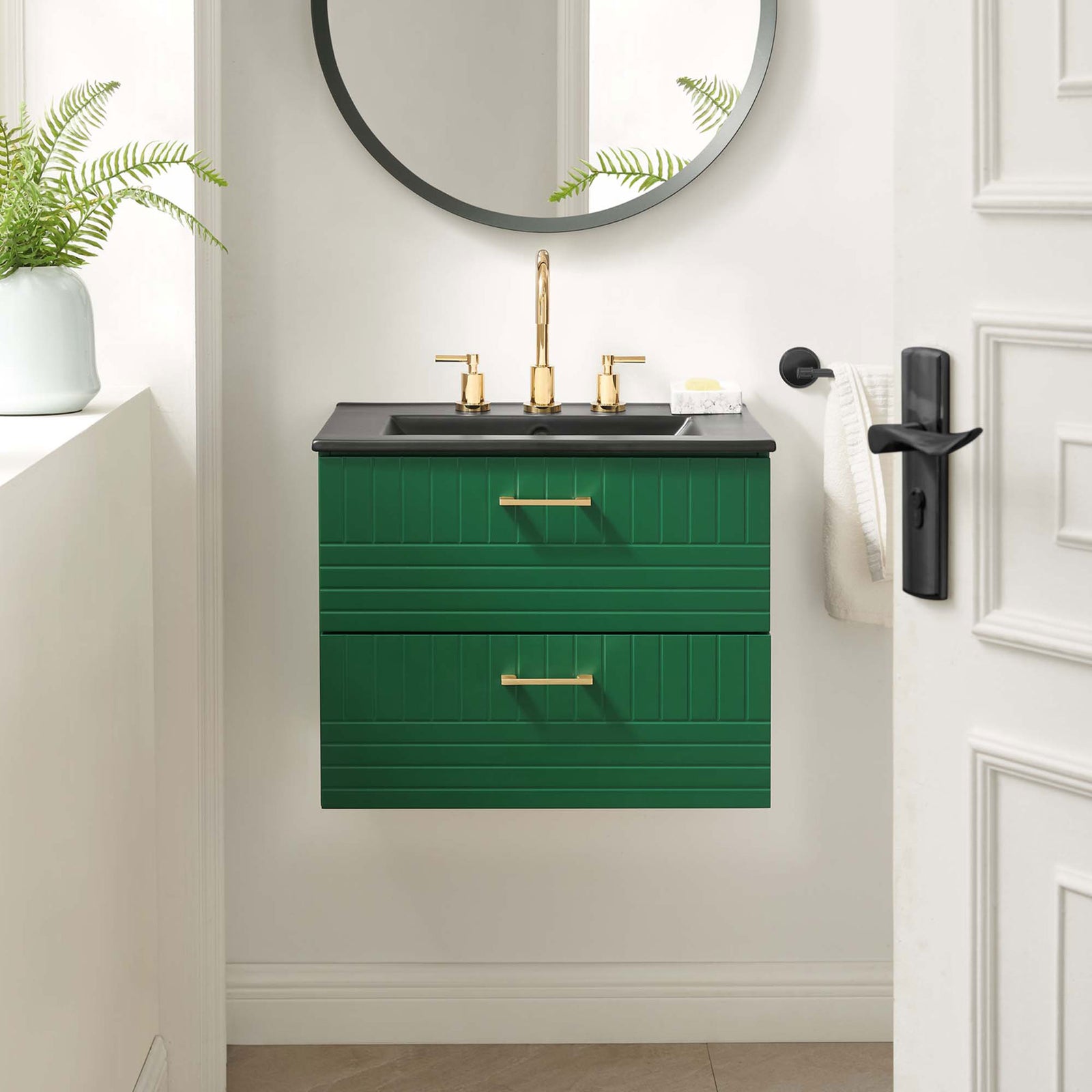 Wall-mounted green vanity anchors the bath with a matte black sink and gleaming gold accents. || EEI-5820-GRN-BLK || front_room