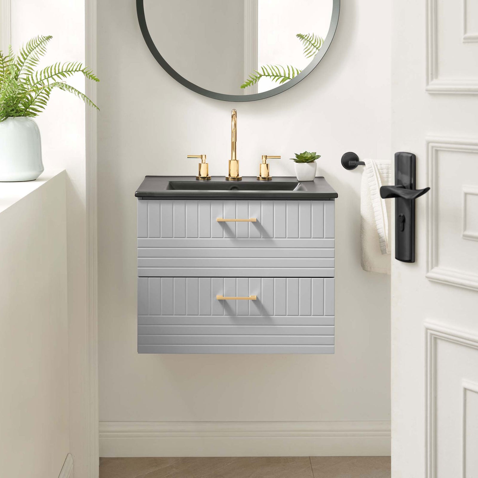Floating 24-inch vanity elevates the bath with a crisp gray finish, black sink, and warm gold accents || EEI-5820-LGR-BLK || front_room