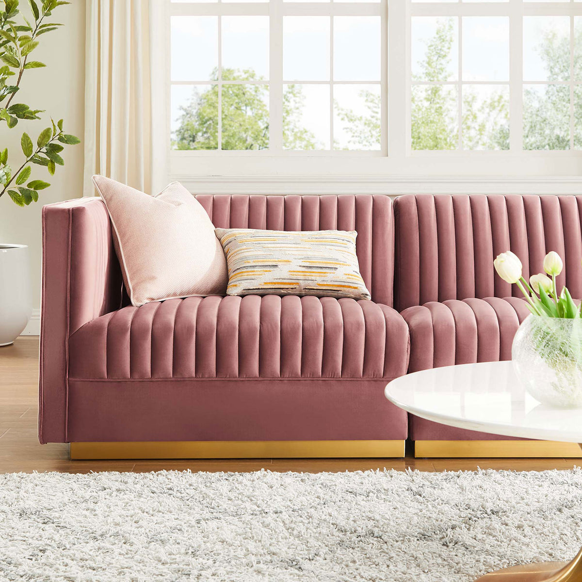 Cozy dusty rose velvet sectional styled with accent pillows and gold base in a bright living room || EEI-5825-DUS || detail_room