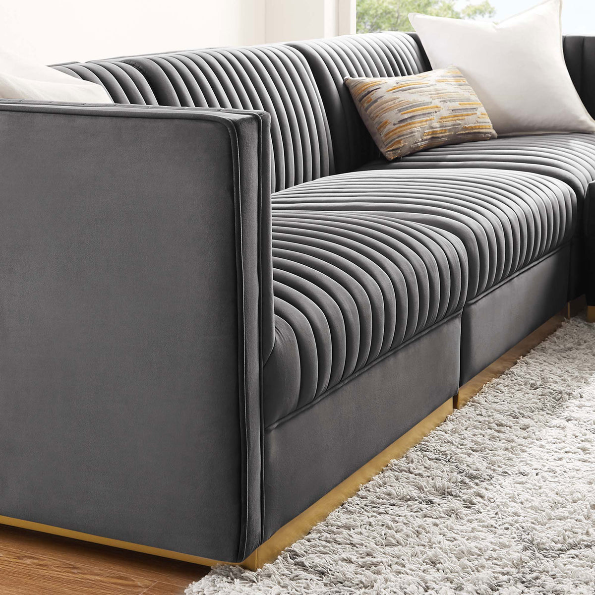 Gray velvet channel tufted sectional adds soft texture and shine beside a cozy area rug || EEI-5826-GRY || detail_room