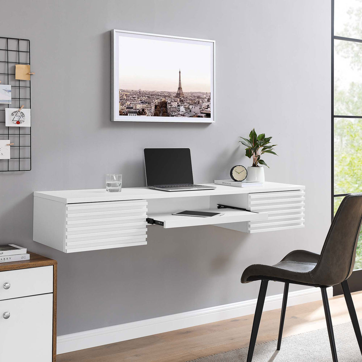 Wall-mounted white desk styled in a modern workspace with the keyboard tray extended || EEI-5865-WHI || front_angle_open_room