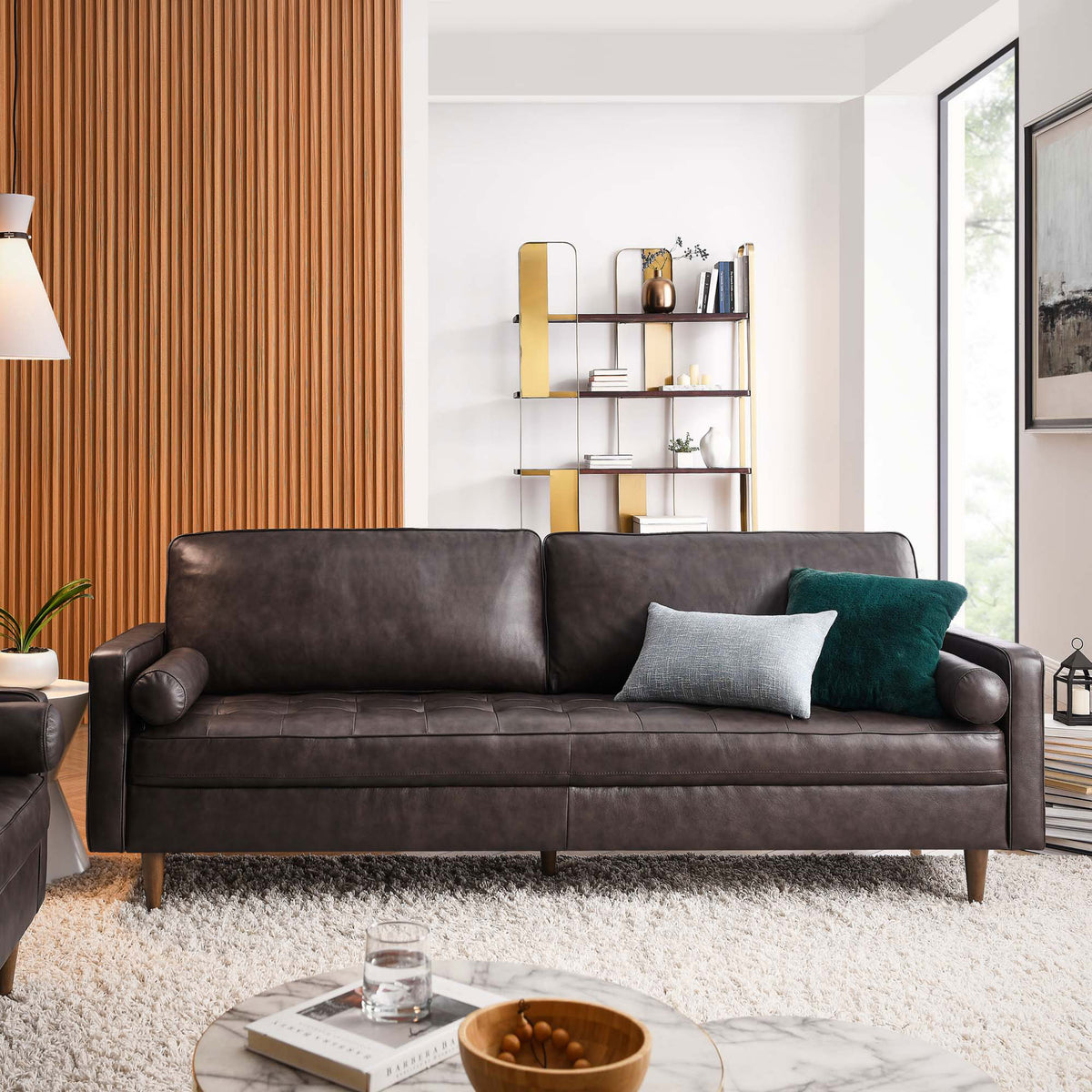 Spacious brown leather sofa anchors a modern living room with plush cushions, bolster pillows, and warm accents || EEI-5871-BRN || front_angle_room