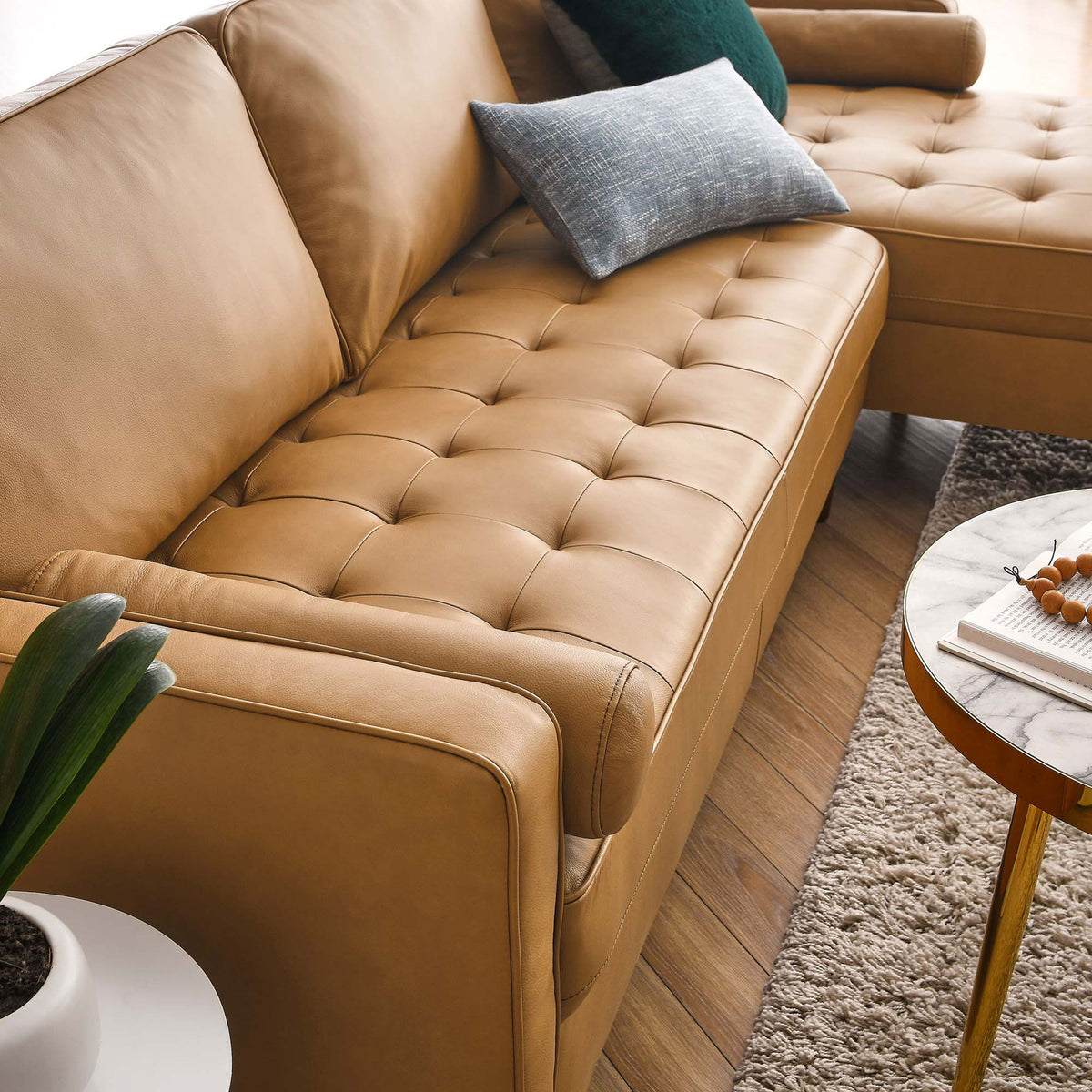 Biscuit tufted tan leather seat cushions paired with accent pillows, wood side table, and cozy area rug. || EEI-5873-TAN || detail_room