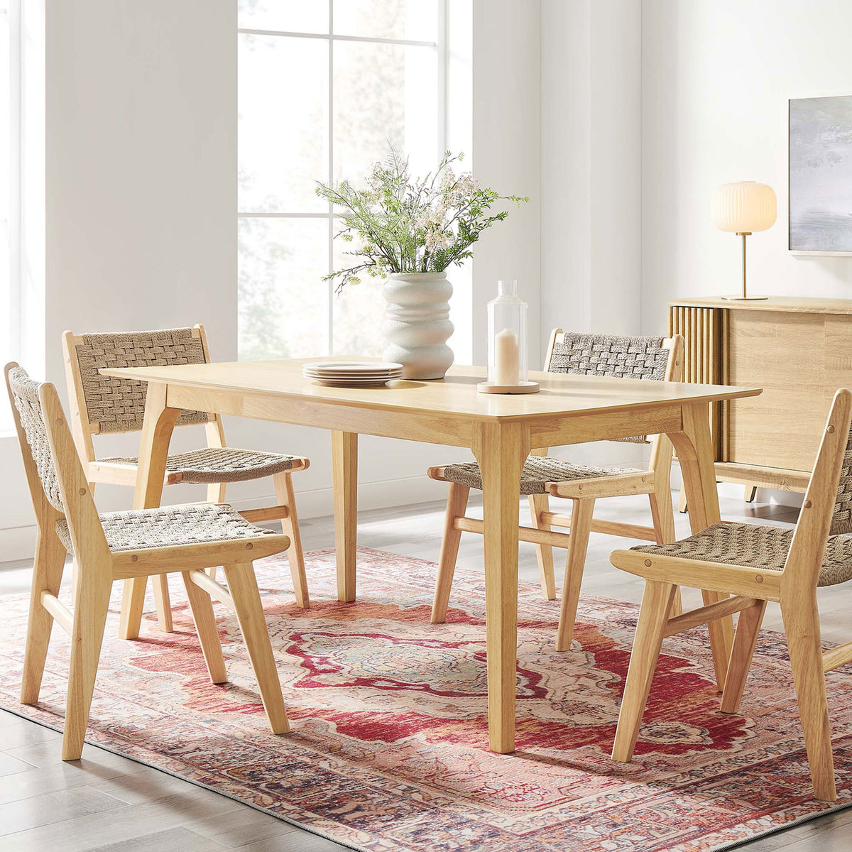Oak dining table styled with woven chairs and decor in a bright, inviting dining room || EEI-6017-OAK-OAK || front_angle_room