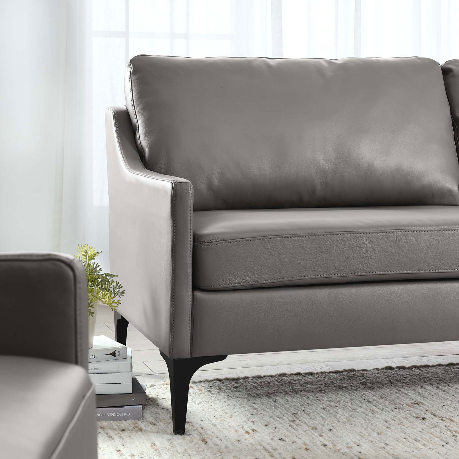 Gray leather sofa arm and cushions styled in a bright living room with soft natural light || EEI-6018-GRY || detail_room