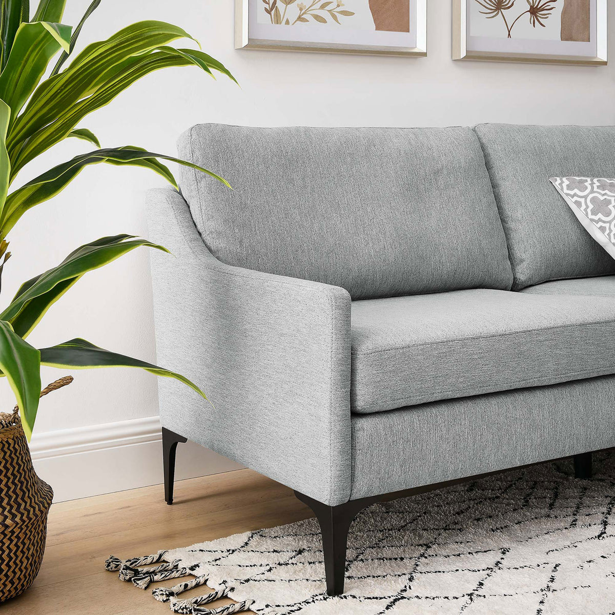 Light gray sofa styled in a modern living room with patterned rug, plant, and slim black legs || EEI-6019-LGR || detail_room