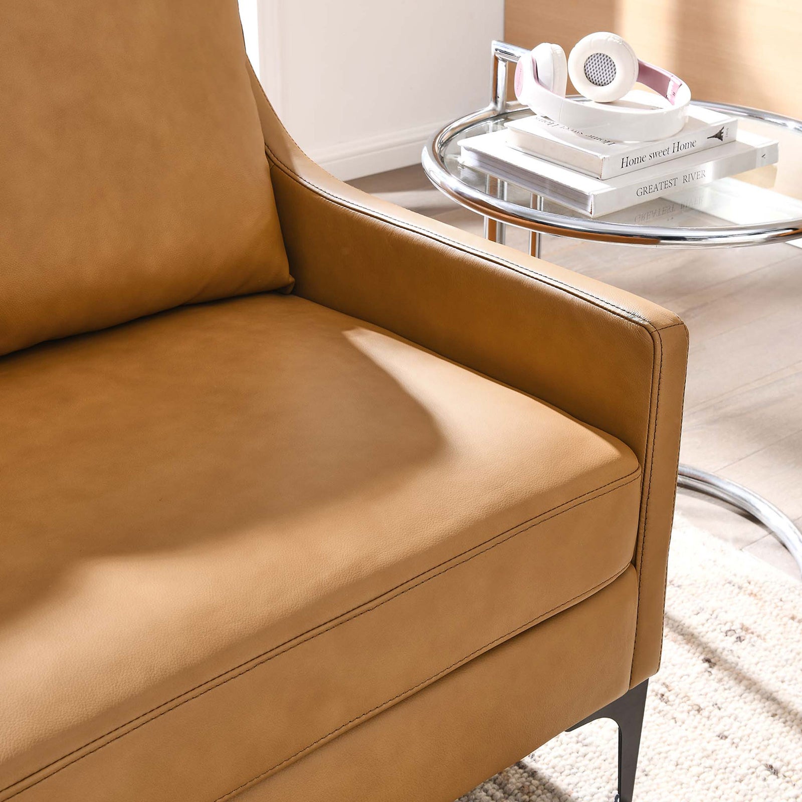Lifestyle close up of tan leather loveseat arm with plush cushion beside a modern side table || EEI-6020-TAN || detail_room