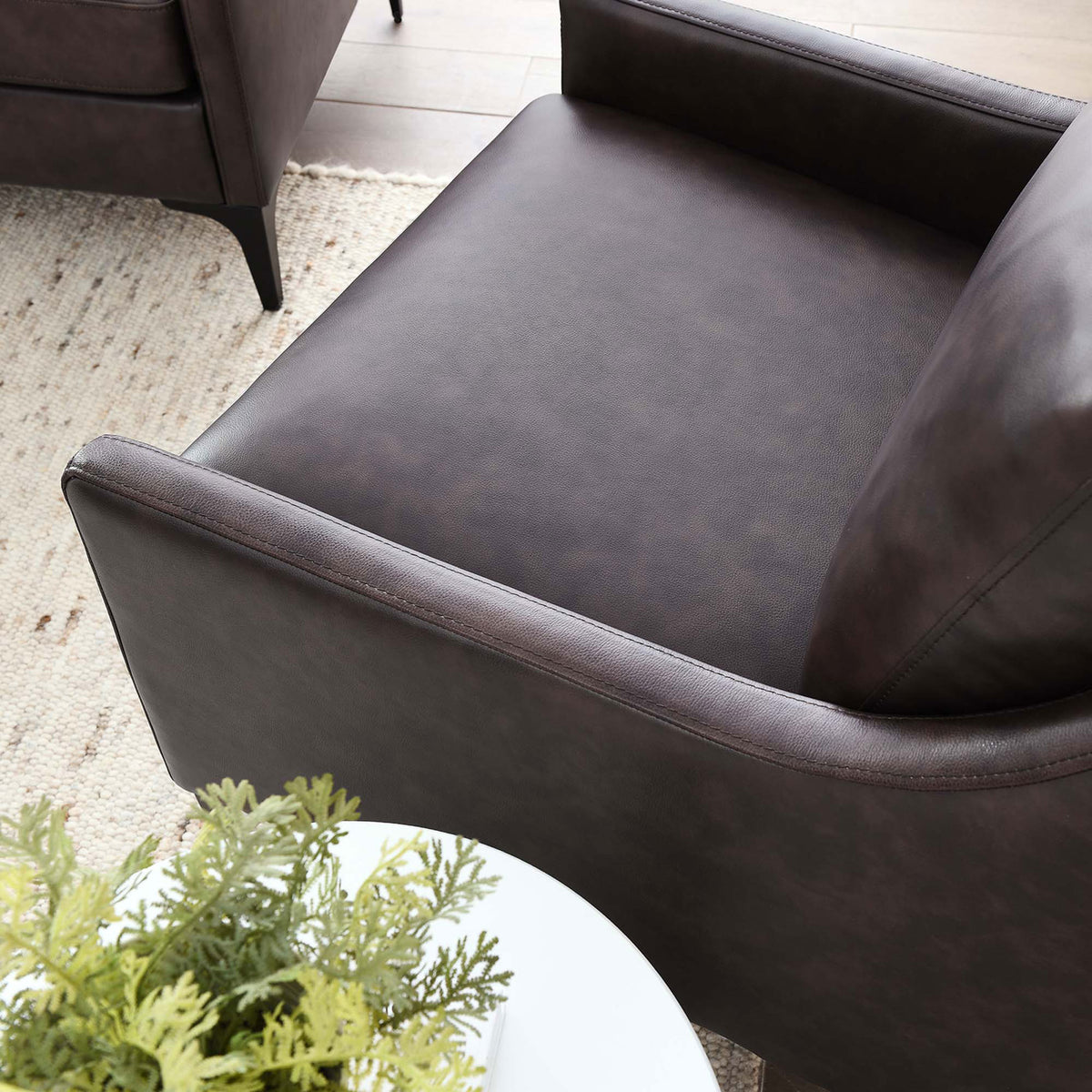 Smooth leather seat and gently curved armrest bring elevated comfort to modern living spaces || EEI-6022-BRN || detail_room