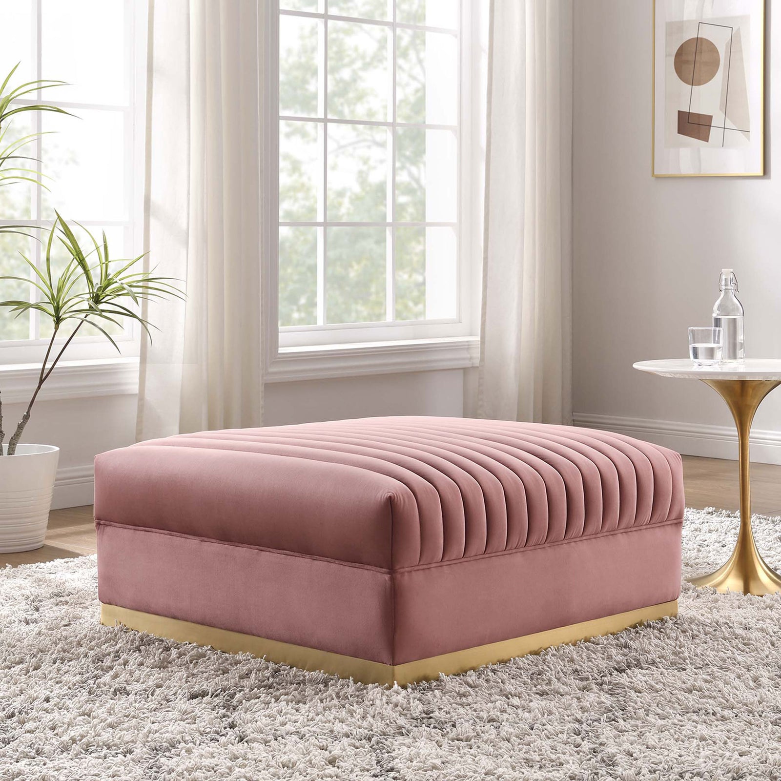 Dusty rose velvet ottoman brings glam comfort to a bright modern living room with gold accents || EEI-6036-DUS || front_angle_room
