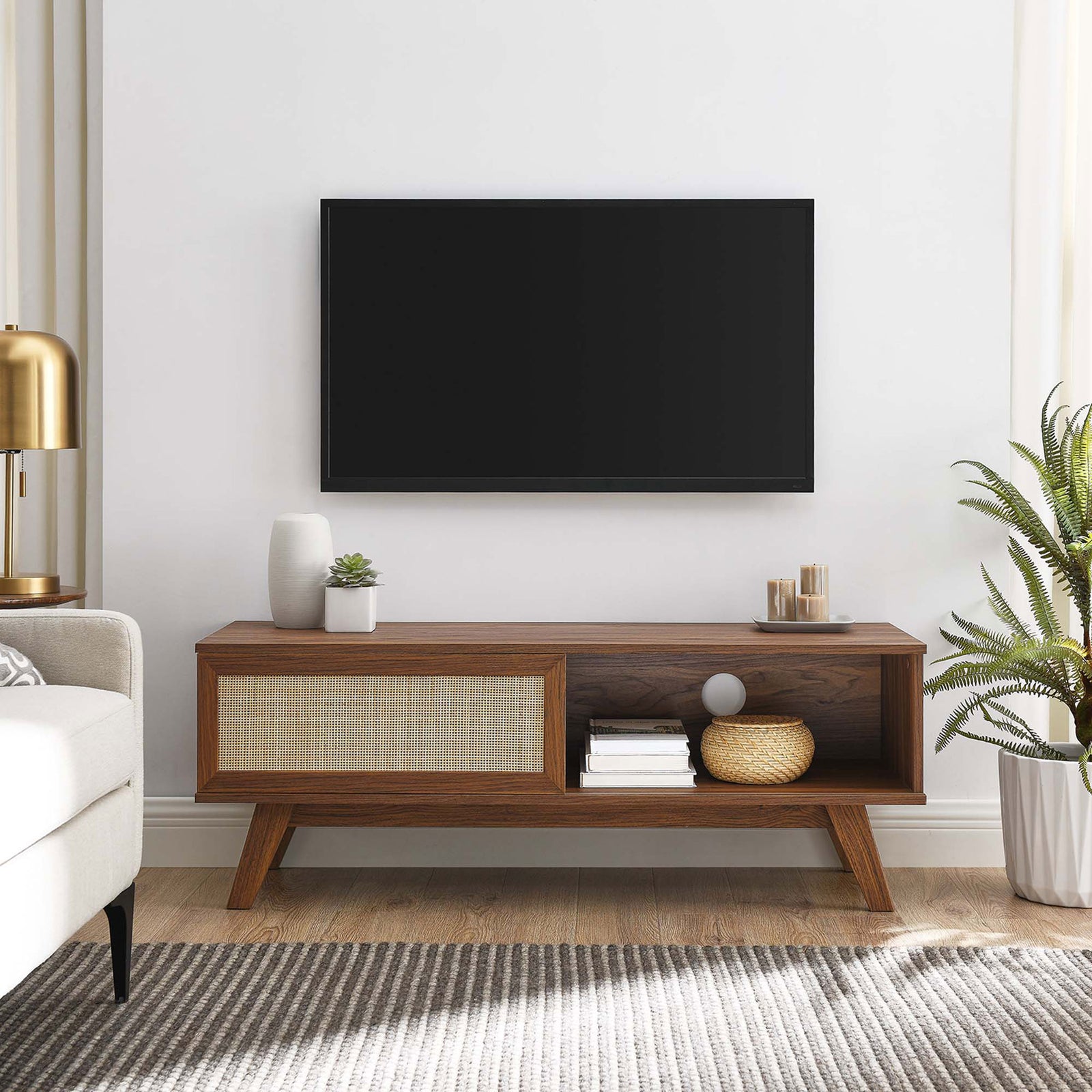 Walnut tv stand with rattan sliding door and open shelf styled in a modern living room || EEI-6039-WAL || front_angle_room