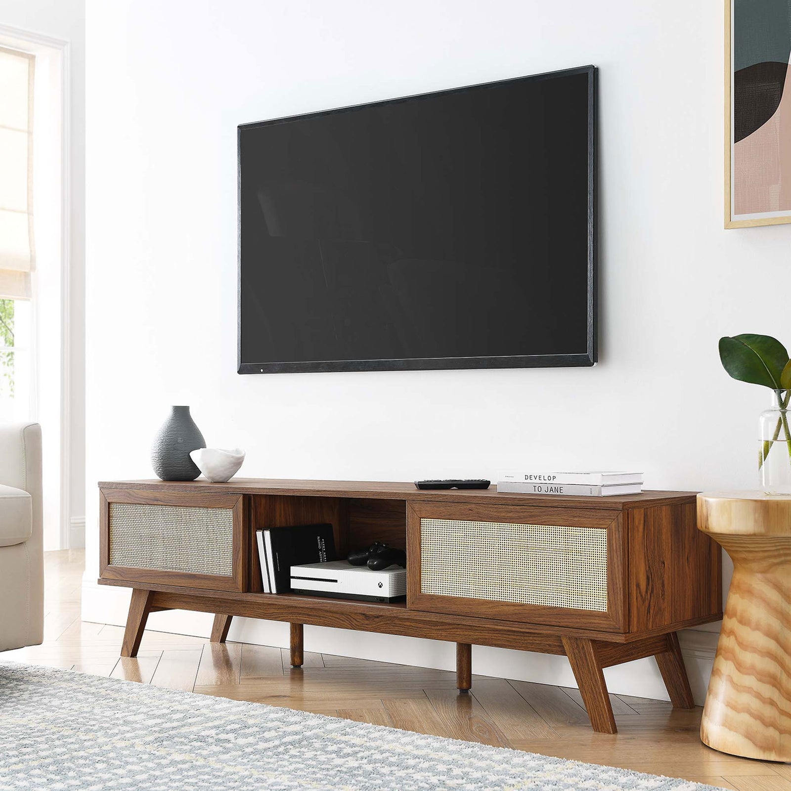 Walnut tv stand with dual rattan doors and open shelf styled beneath a wall-mounted tv || EEI-6040-WAL || front_angle_room