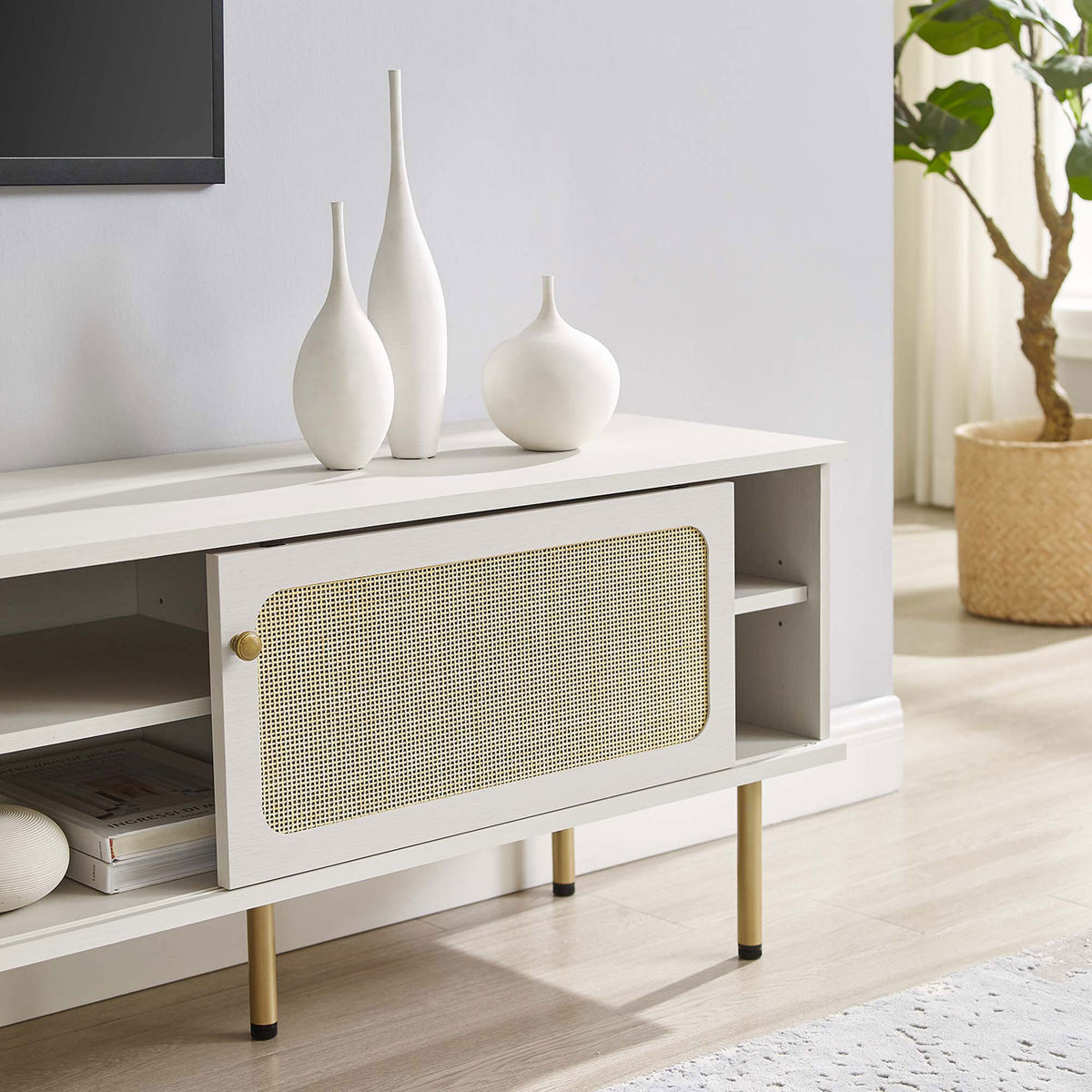 White rattan TV stand stretching beneath a wall-mounted TV with vases and books in a serene room. || EEI-6046-WHI || storage_room