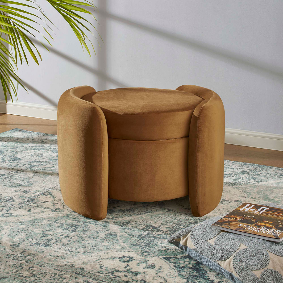 Cognac velvet ottoman placed on a patterned rug in a bright living room, ready for extra seating or storage || EEI-6055-COG || front_angle_room