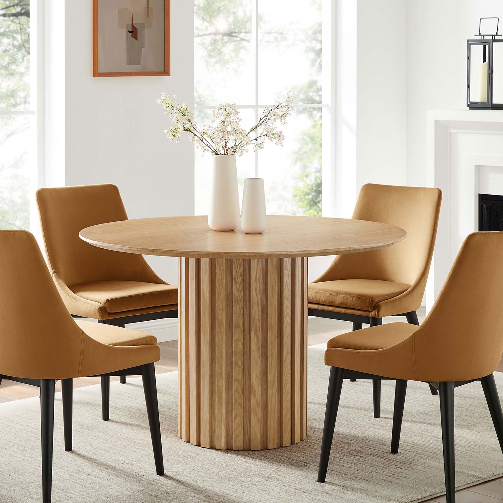 Senja round oak dining table styled in a bright dining room with four upholstered chairs || EEI-6064-OAK-SET || front_angle_room