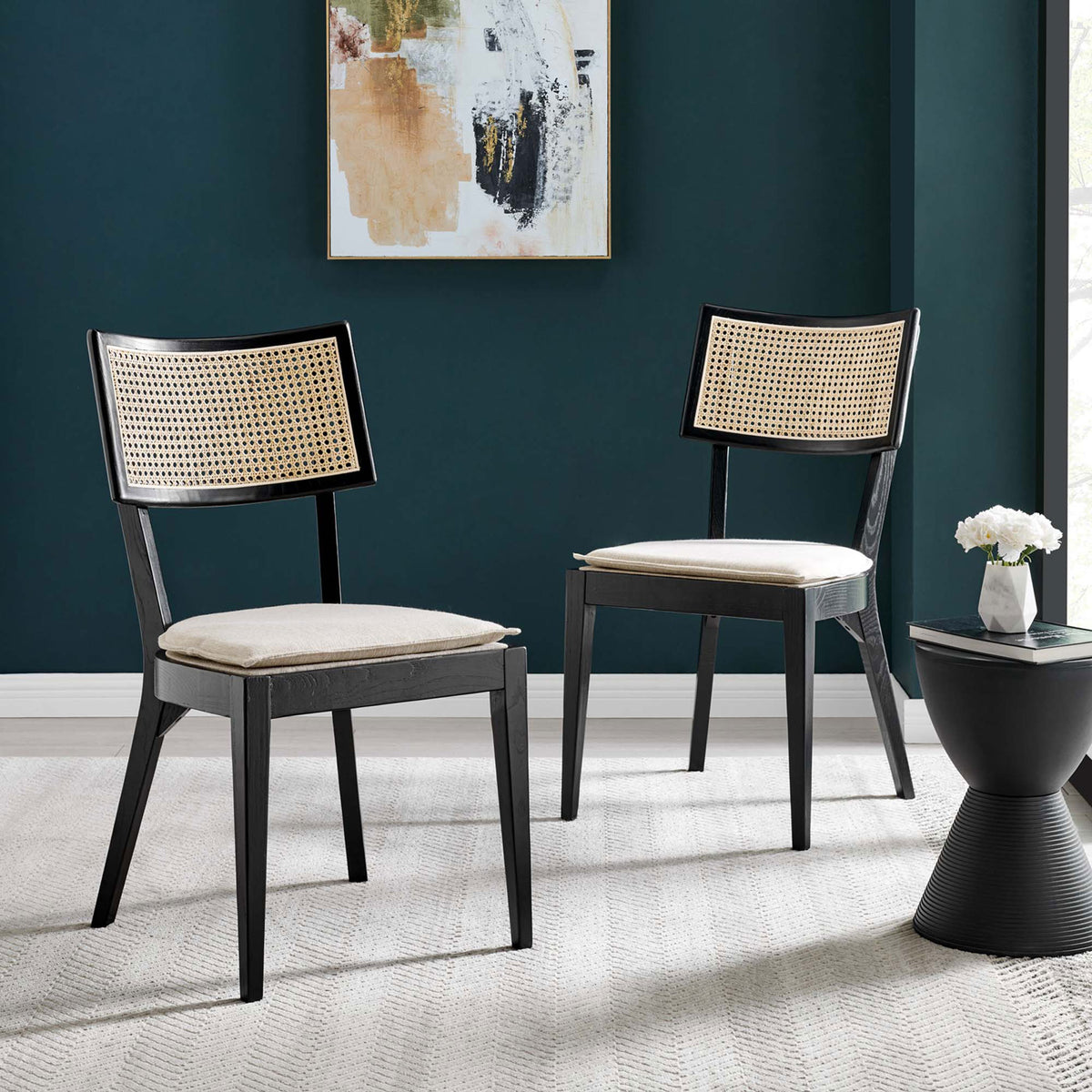 Pair of black wood dining chairs with rattan backs and beige cushions arranged in a stylish dining nook || EEI-6080-BLK-BEI || front_angle_multi_room