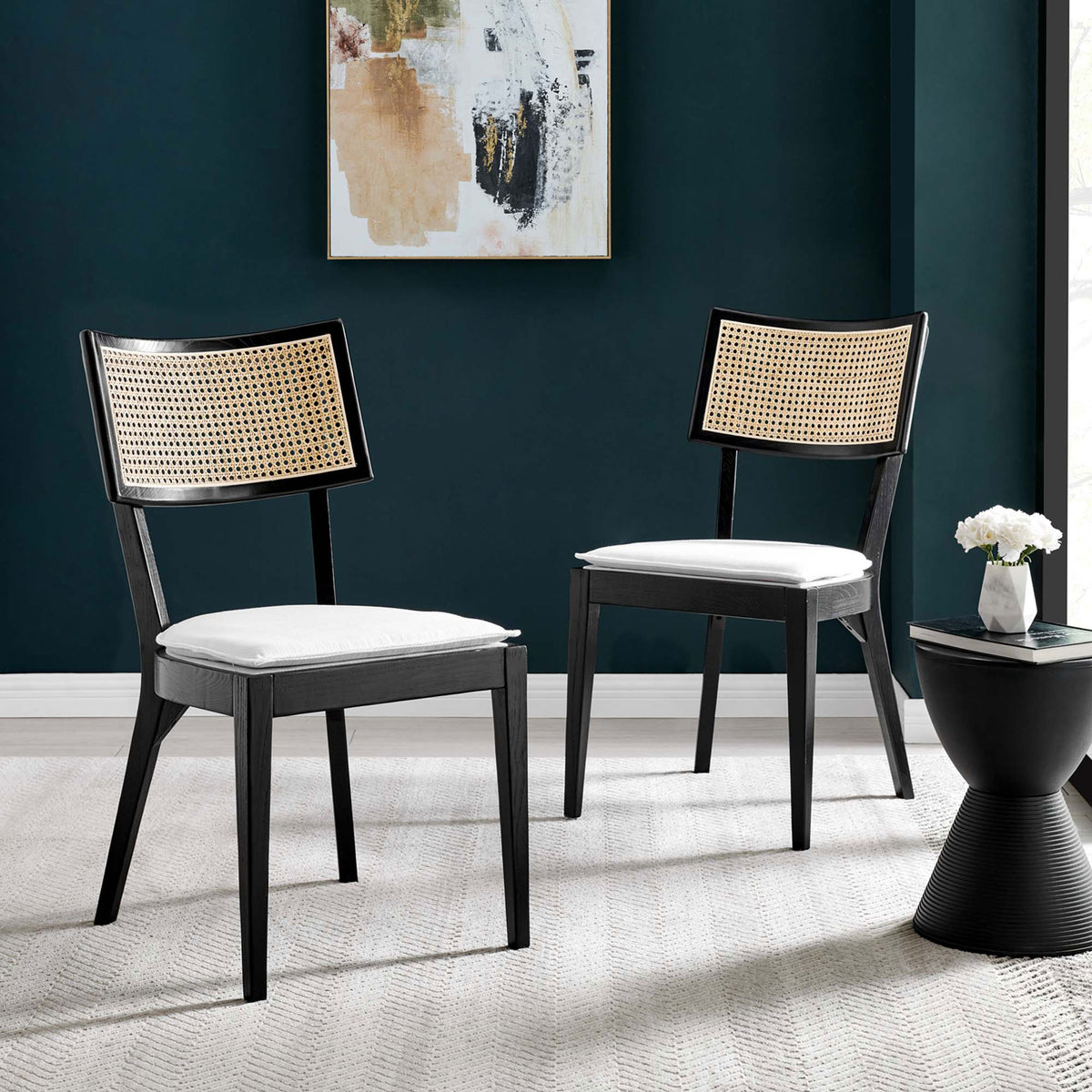 Set of two black wood dining chairs with rattan backs and white cushions in a chic room || EEI-6080-BLK-WHI || front_angle_multi_room