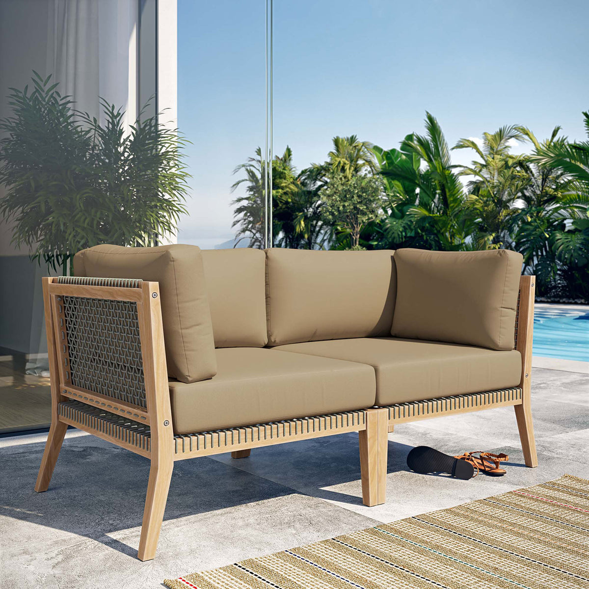 Clearwater teak loveseat with light brown cushions styled on a sunlit poolside patio || EEI-6119-GRY-LBR || front_angle_room