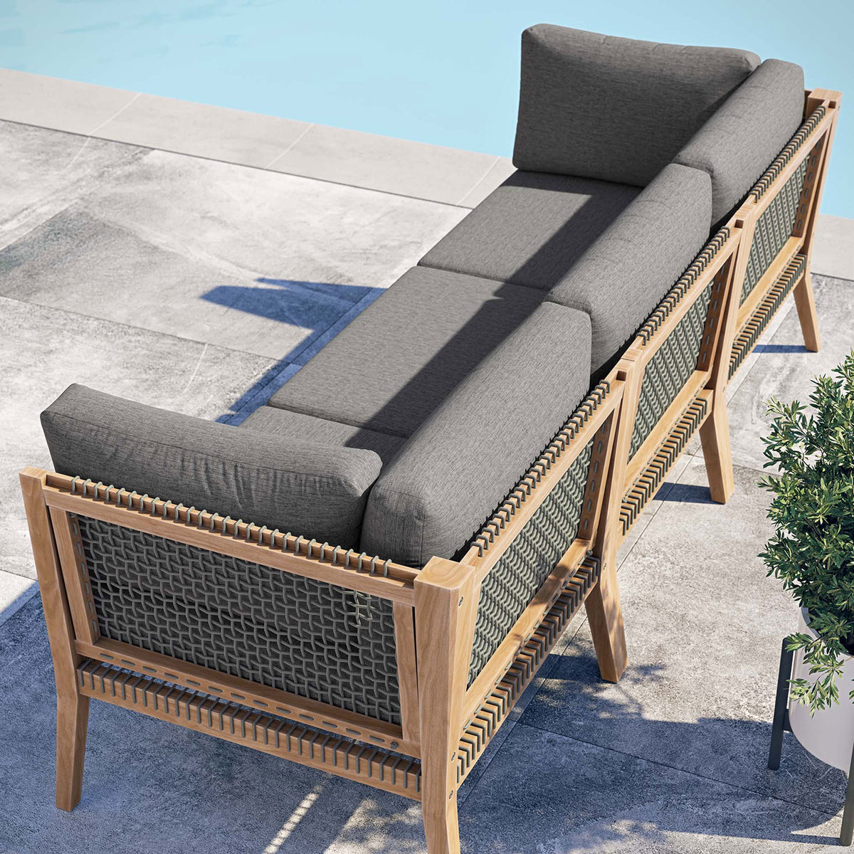 Gray graphite outdoor sofa poolside showing rope back panels and teak frame || EEI-6120-GRY-GPH || back_angle_room