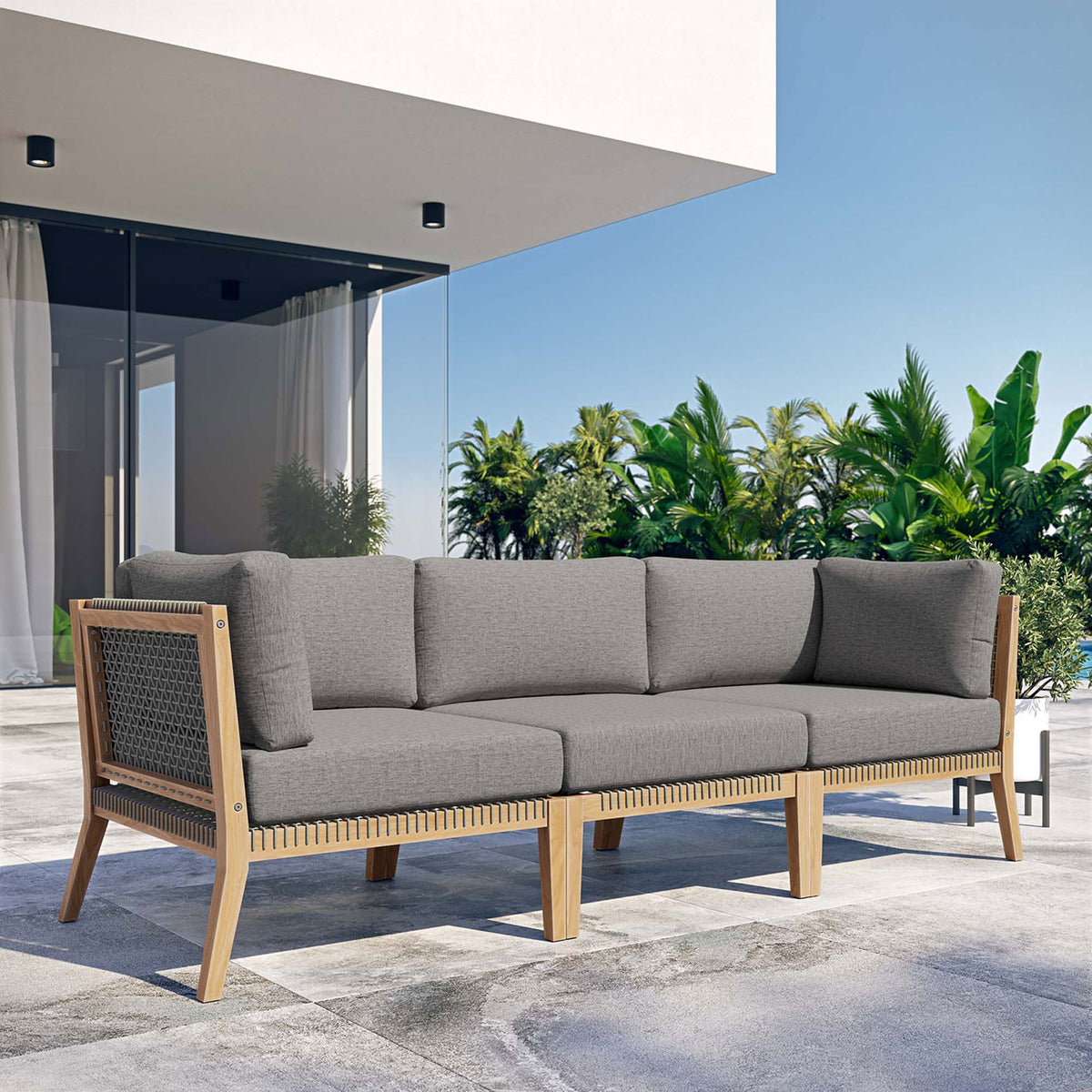 Gray graphite teak outdoor sofa creating a modern lounge on a sunny patio || EEI-6120-GRY-GPH || front_angle_room