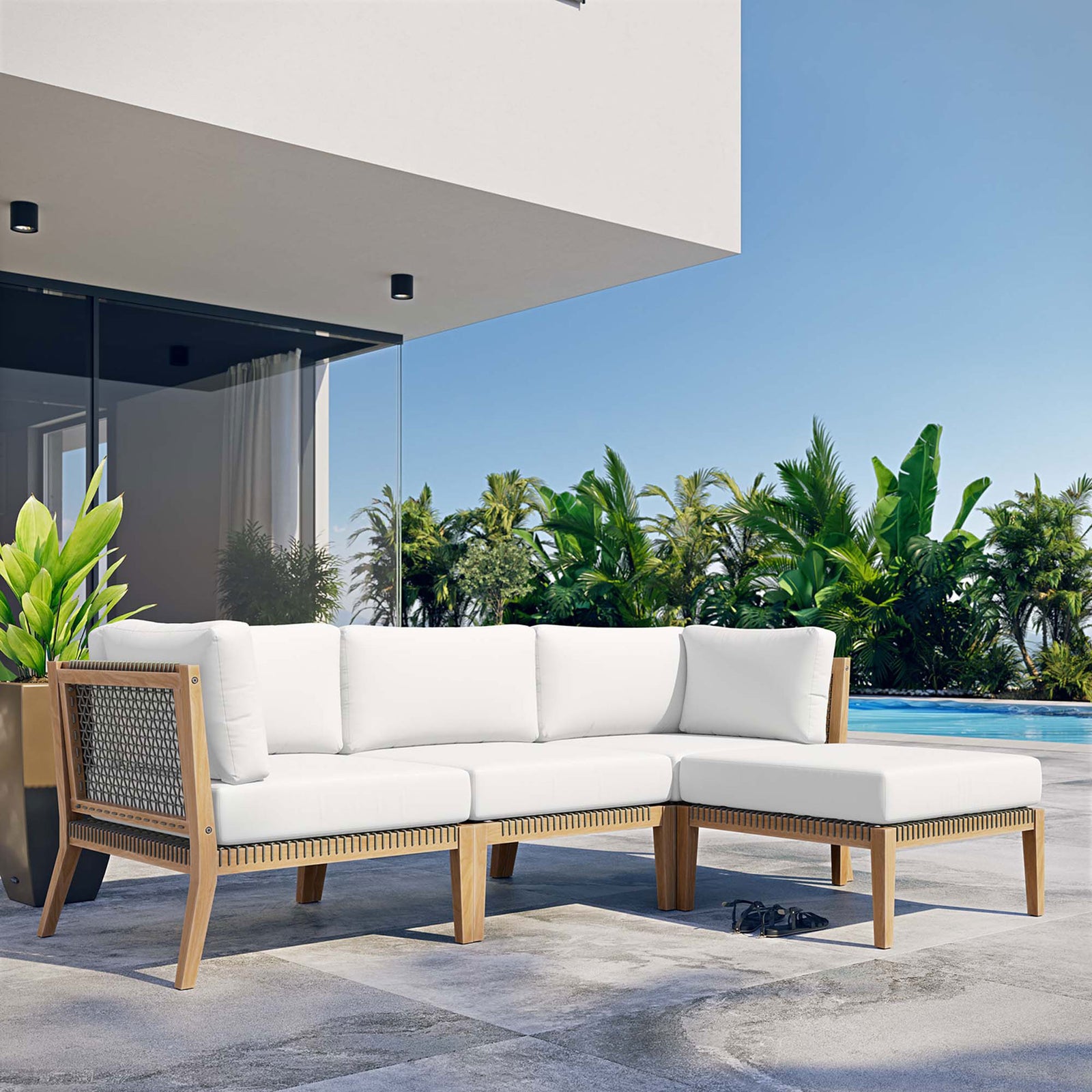White teak sectional sofa by the pool framed by palm trees and modern architecture || EEI-6121-GRY-WHI || front_angle_room