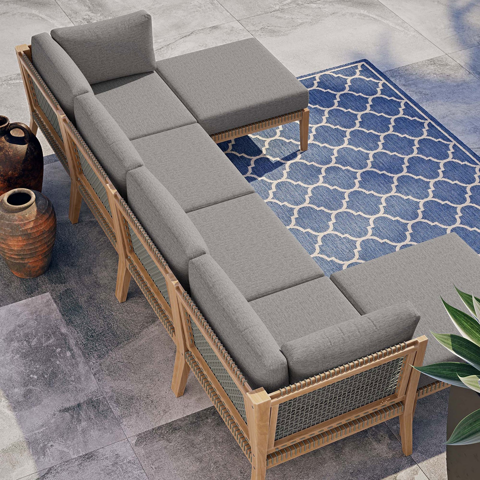 Graphite gray teak sectional styled on a modern patio with blue patterned rug and planters || EEI-6122-GRY-GPH || top_angle_room