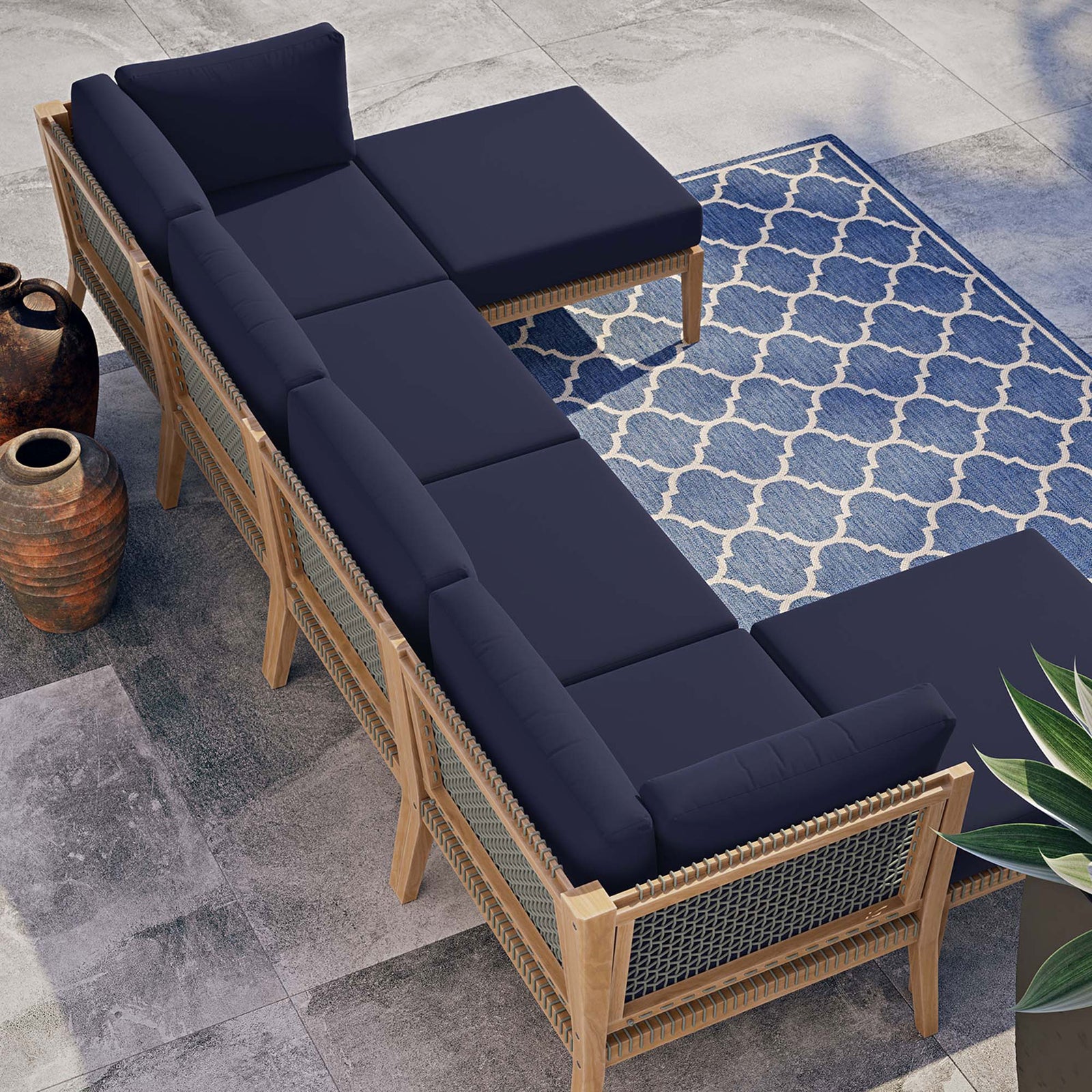 Navy blue teak sectional styled on a modern patio with blue patterned rug and planters || EEI-6122-GRY-NAV || top_angle_room