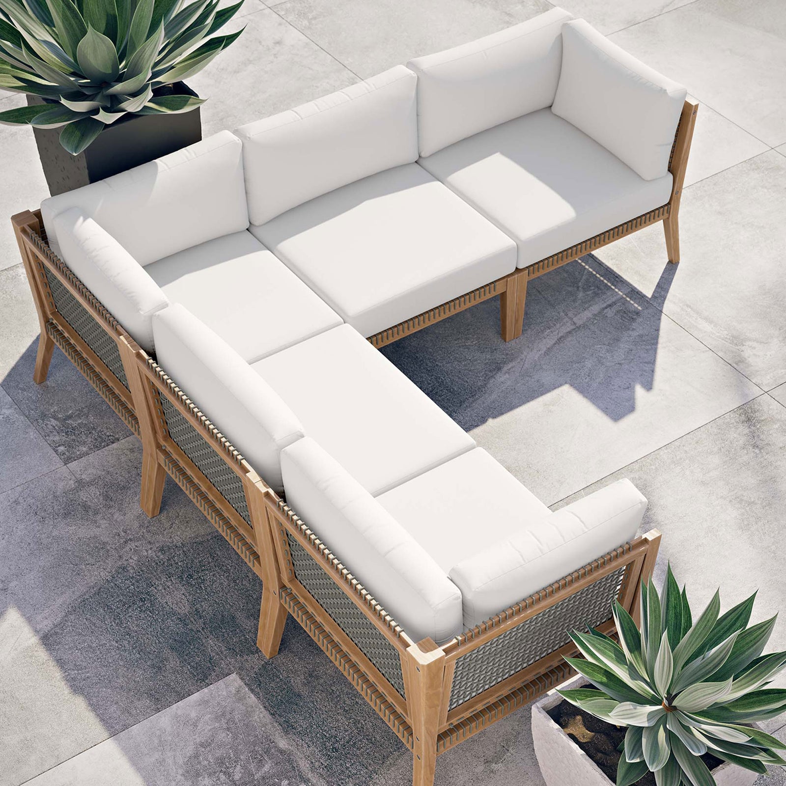 Sunlit patio scene with white sectional arranged in an L shape between modern sculptural planters || EEI-6123-GRY-WHI || top_angle_room