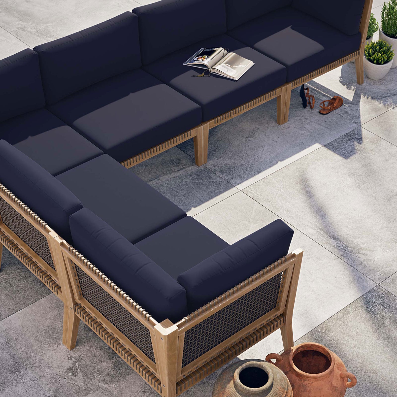 Navy sectional arranged on a modern patio with open book and decor accessories || EEI-6125-GRY-NAV || top_angle_room