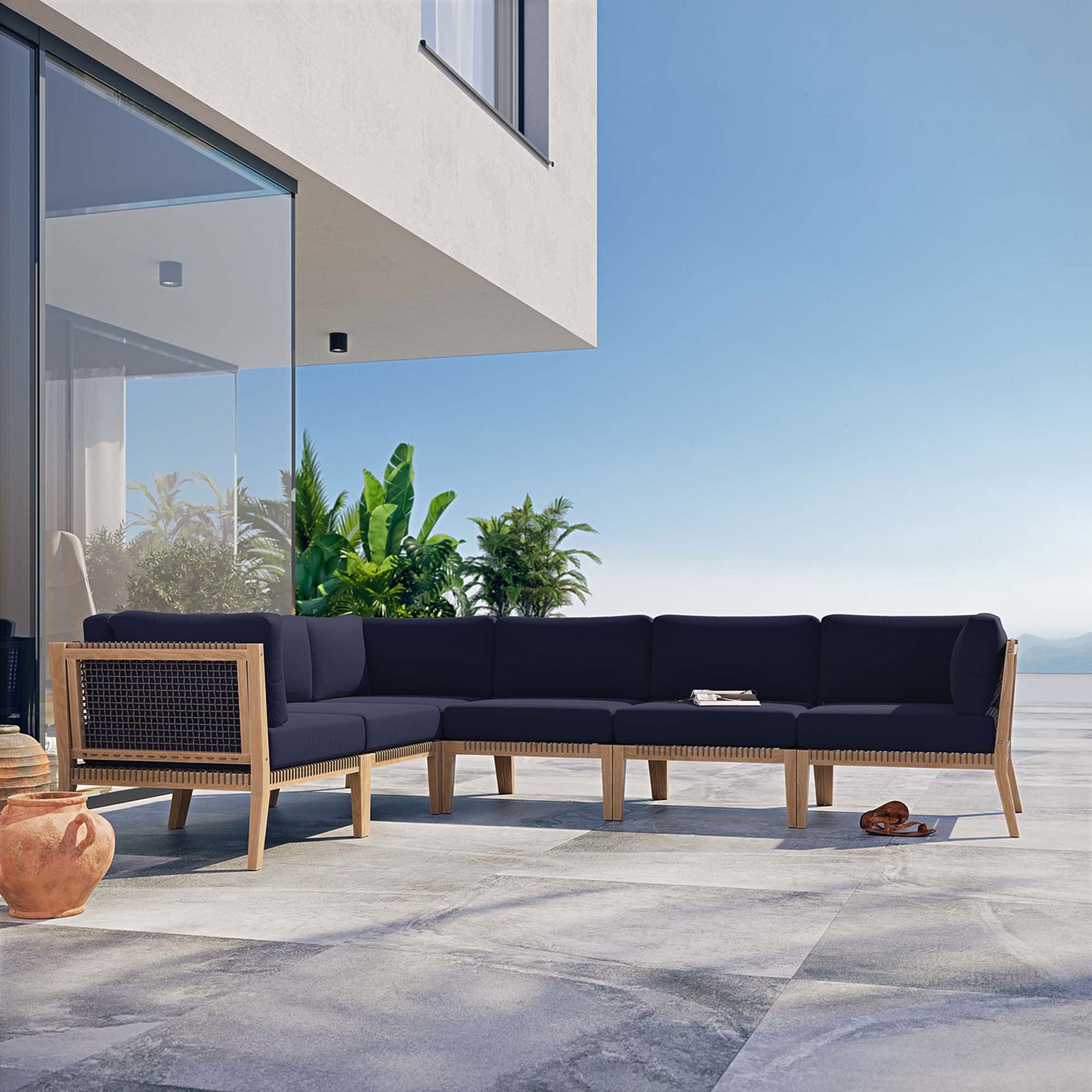 Navy sectional styled on a sunny terrace with ocean and greenery backdrop || EEI-6125-GRY-NAV || front_angle_room