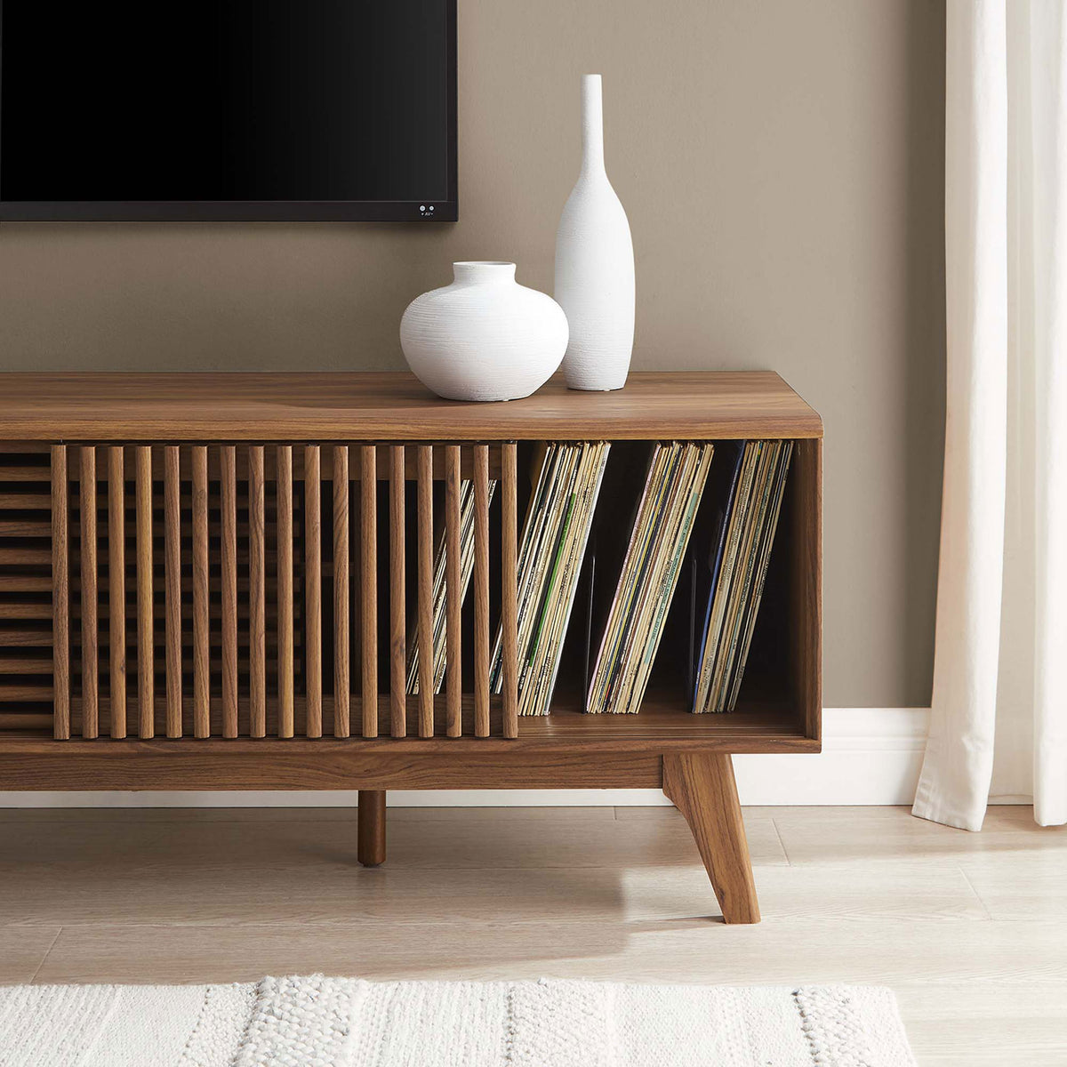 Walnut TV stand in a modern living room with decor and vinyl records neatly stored in the open end compartment || EEI-6180-WAL || storage_room