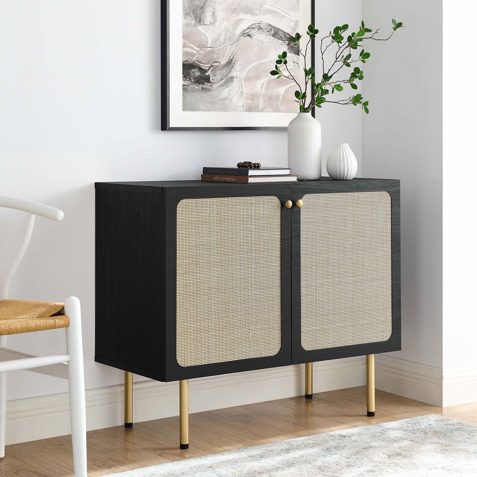 Black rattan accent cabinet styled in a bright living room with art, greenery, and decor accents || EEI-6200-BLK || front_angle_room