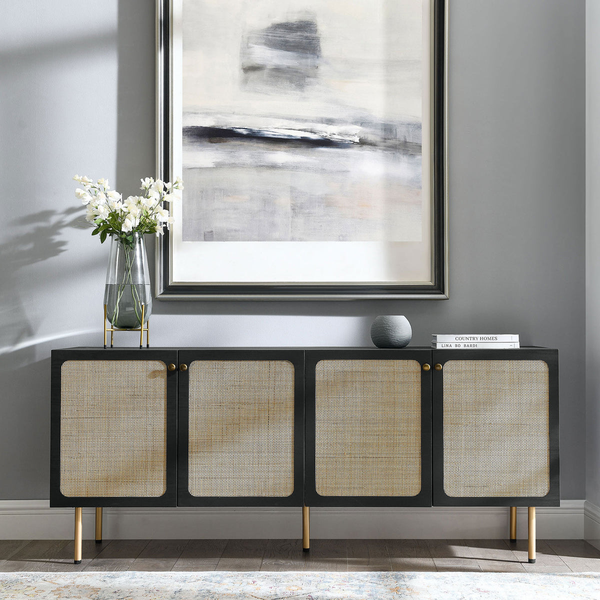 Black rattan front sideboard styled beneath contemporary artwork in a bright modern living space || EEI-6201-BLK || front_angle_room