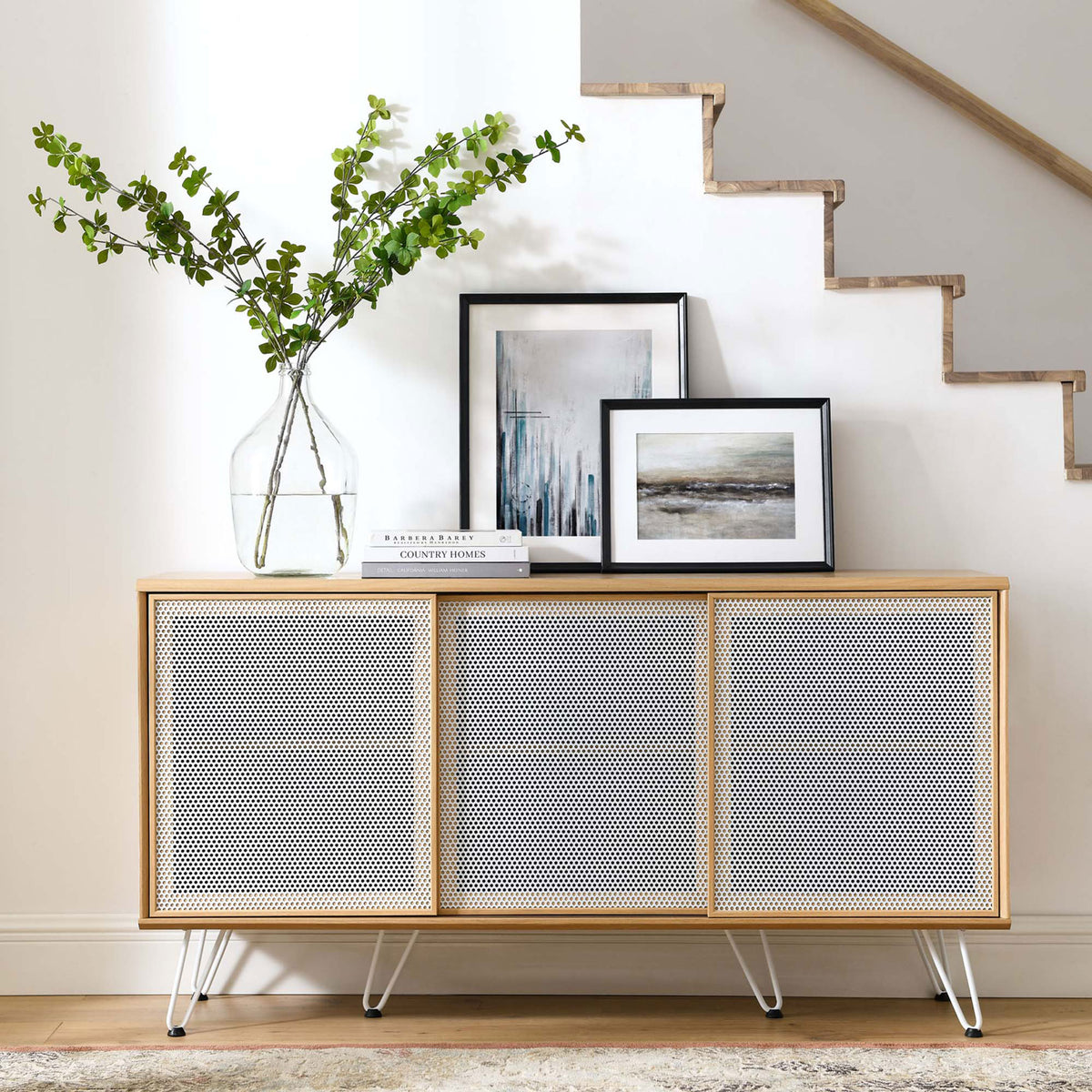 Oak sideboard styled in a bright entryway with framed art and greenery || EEI-6204-OAK || front_room