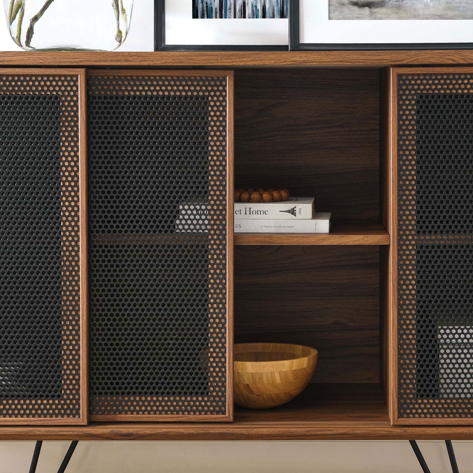 Styled sideboard shelf space storing books and decor behind a partially opened mesh door. || EEI-6204-WAL || storage_open_room