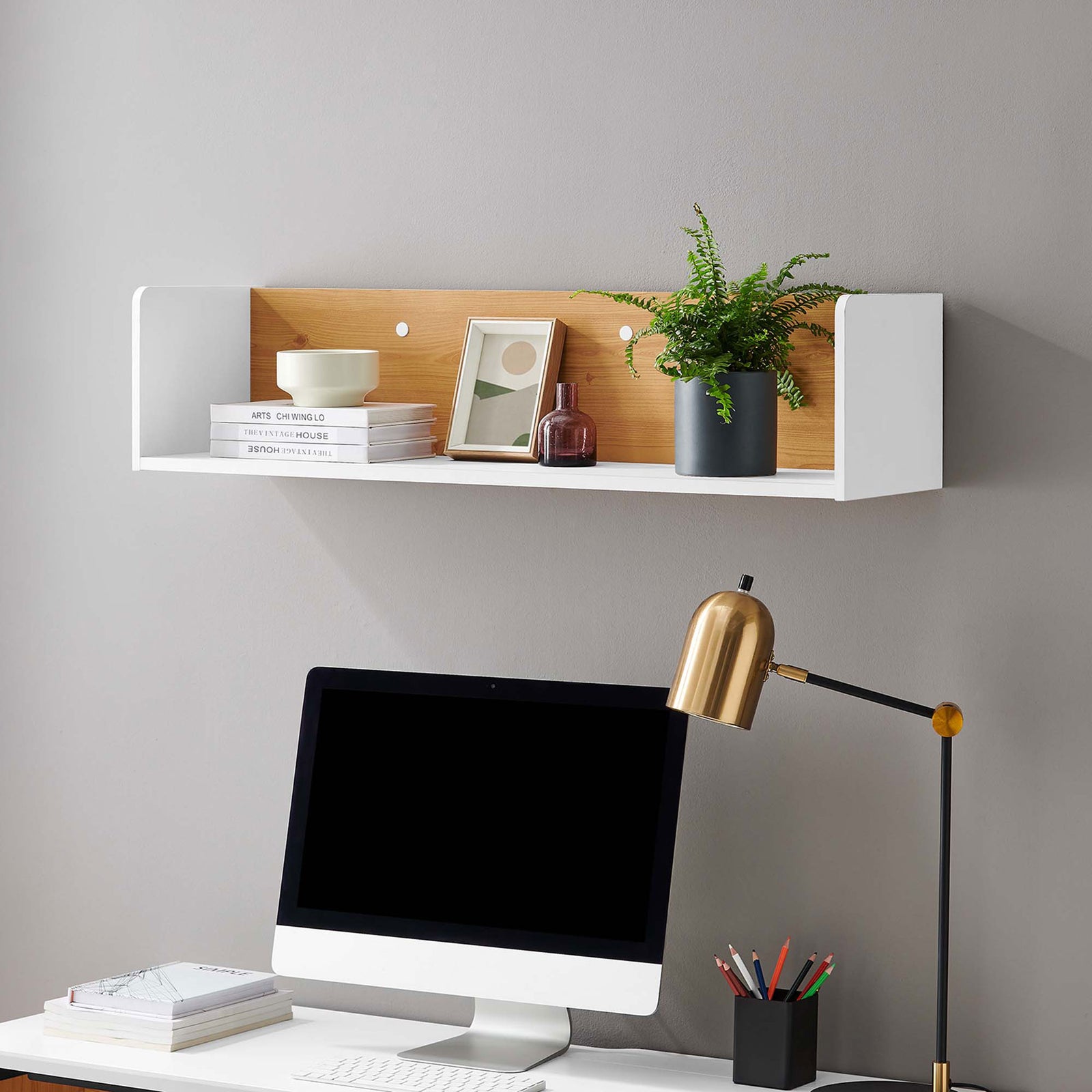 White and natural wall shelf mounted above a desk, styled with books, plants, and decor in a bright workspace. || EEI-6208-WHI-NAT || front_angle_room