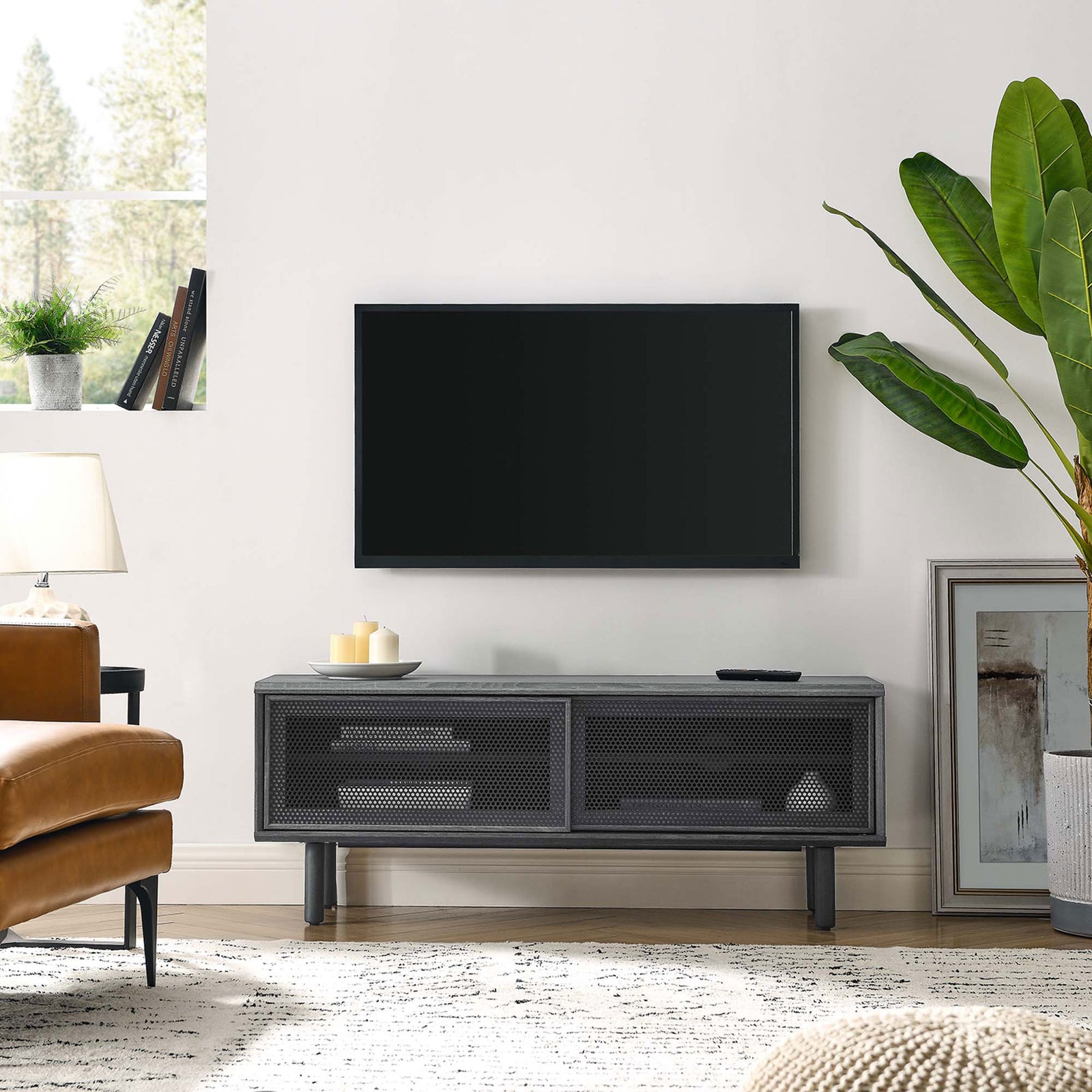 Kurtis 47 in charcoal TV stand in a modern living room beneath a wall-mounted television || EEI-6233-CHA || front_angle_room